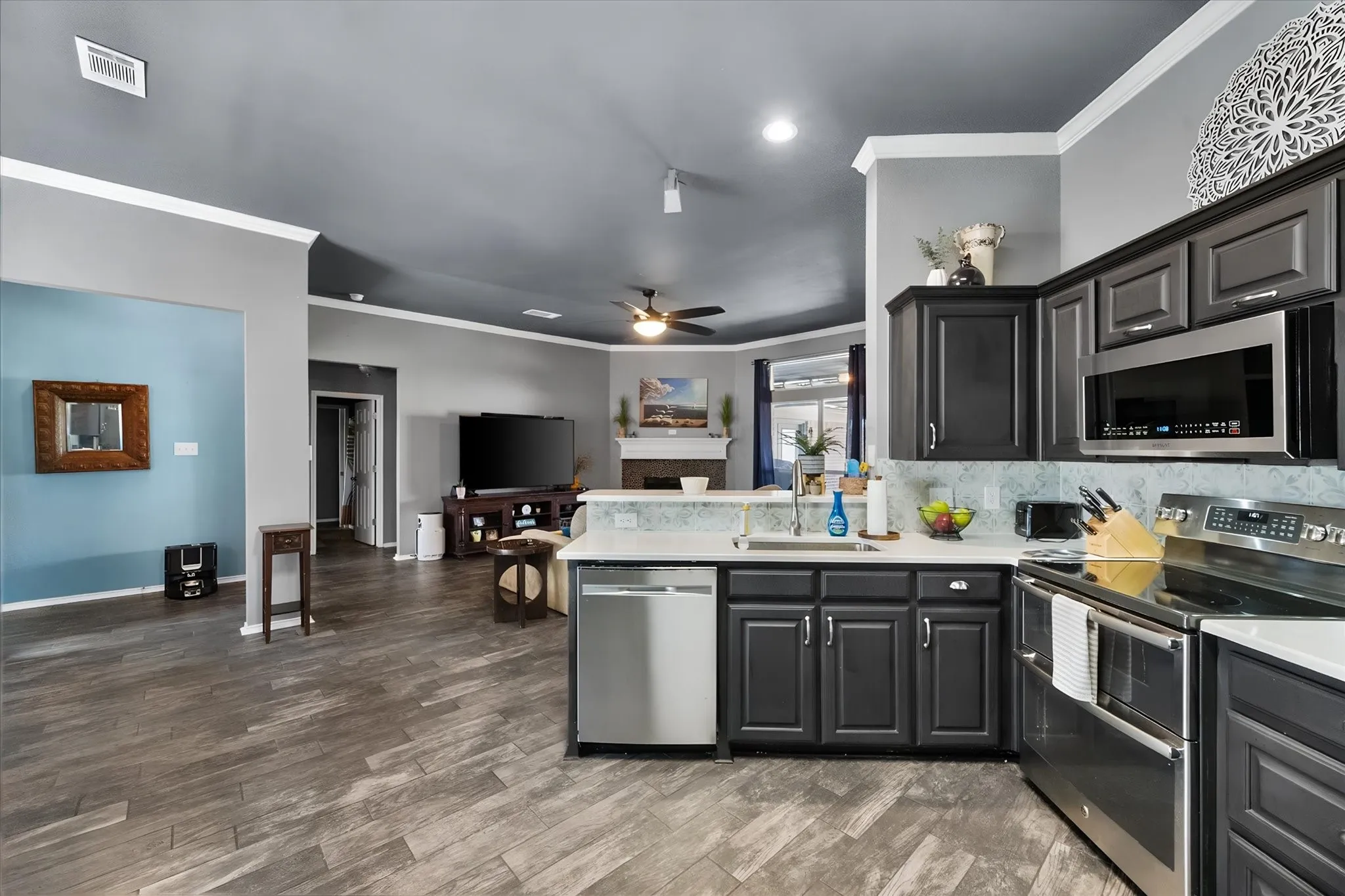 Kitchen with dark wood-finish cabinetry, stainless steel appliances, and light ONYX countertops