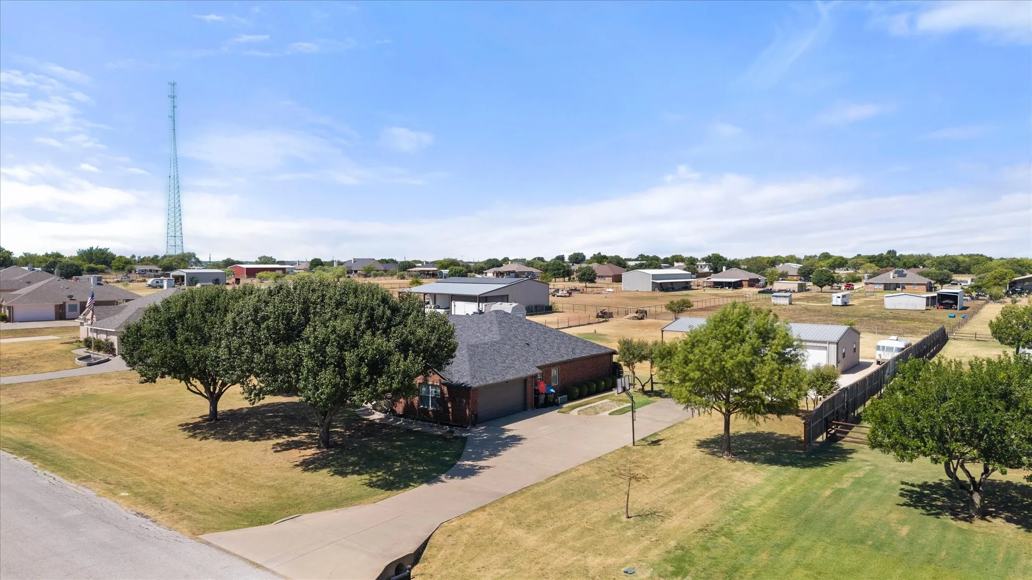 Brick exterior residence with a dark shingle roof.  Expanded Driveway. 30 x 40 ft Workshop