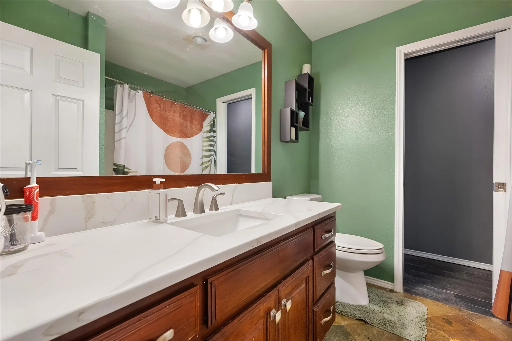 Wood-finish vanity with a white countertop, undermount sink, and brushed nickel faucet