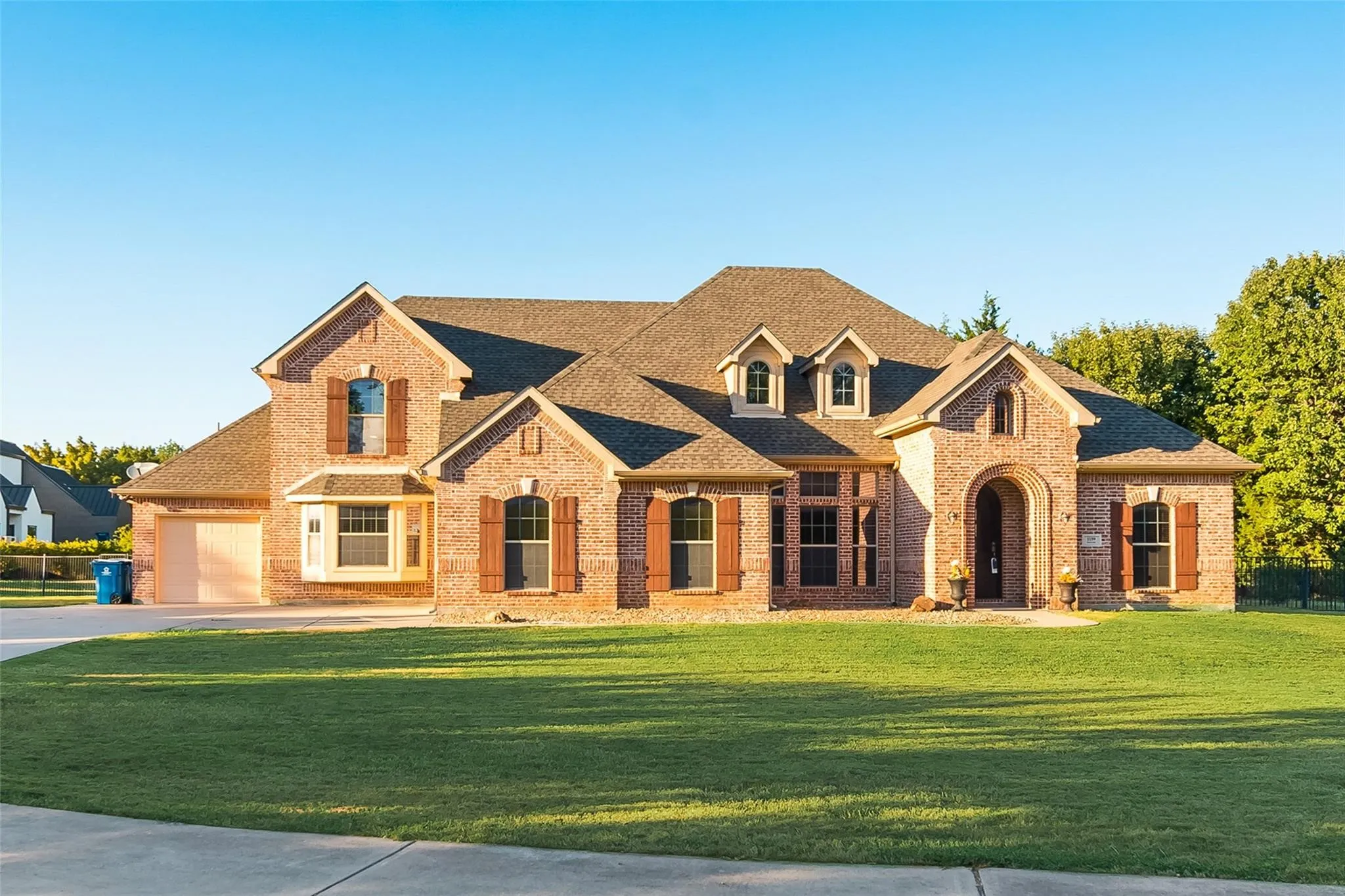 Brick exterior with an arched entryway, dormer windows, and a multi-gabled roofline