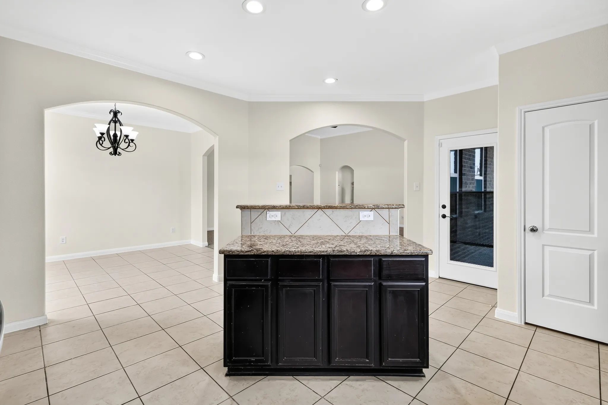 Central island with a stone countertop and dark wood-finish cabinetry