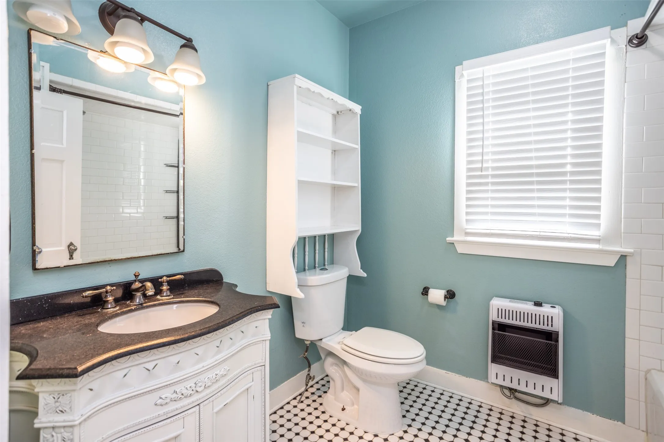 Decorative vanity with dark countertop and undermount sink
