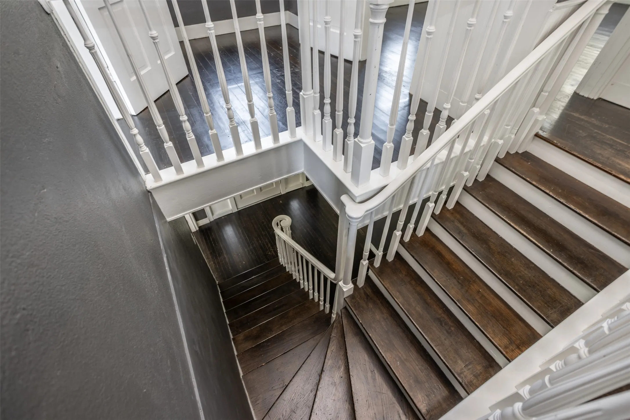 Multi-level staircase featuring wood-finish treads and white balusters