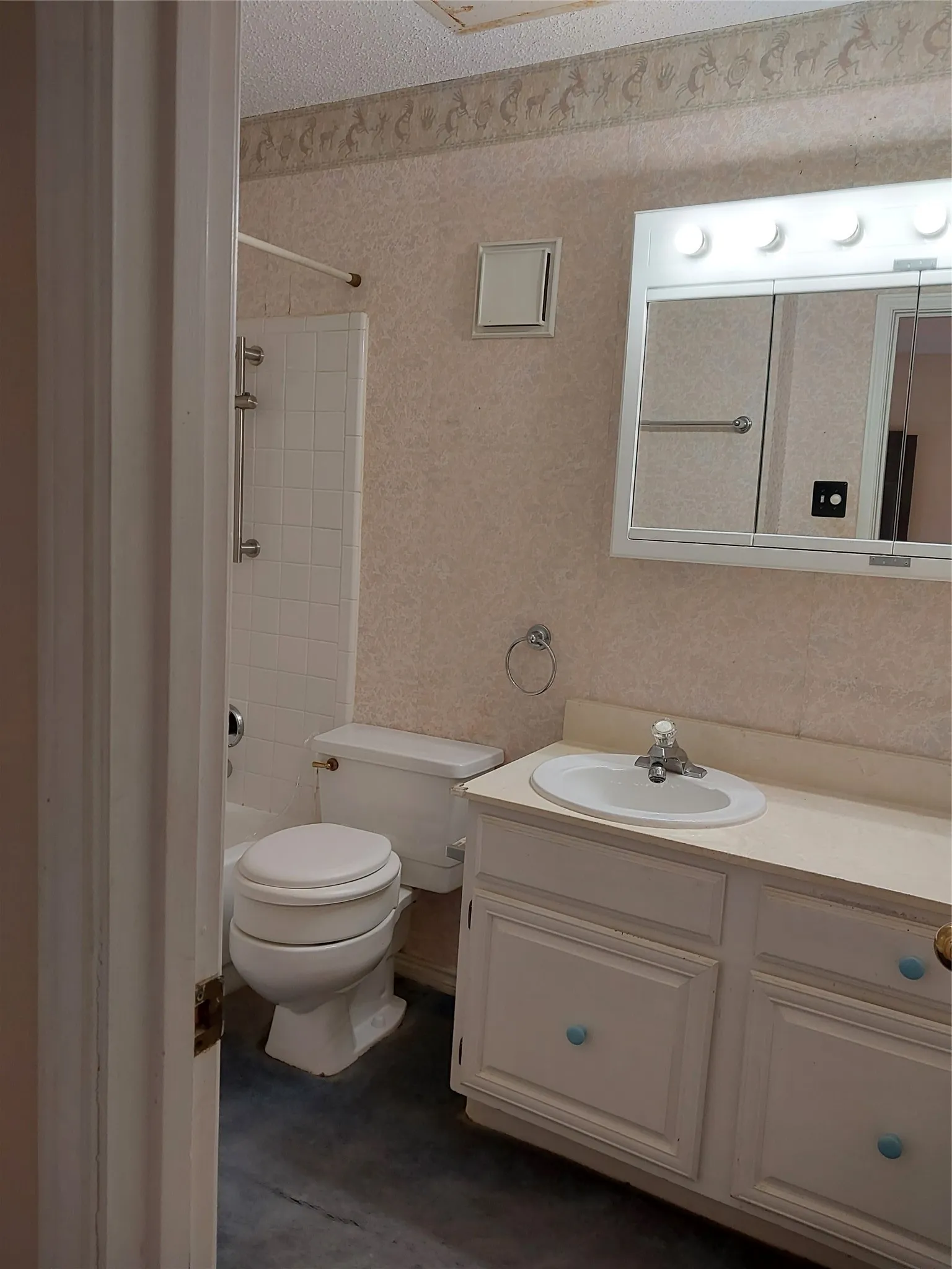 White vanity with a drop-in sink, chrome faucet, and cabinet storage