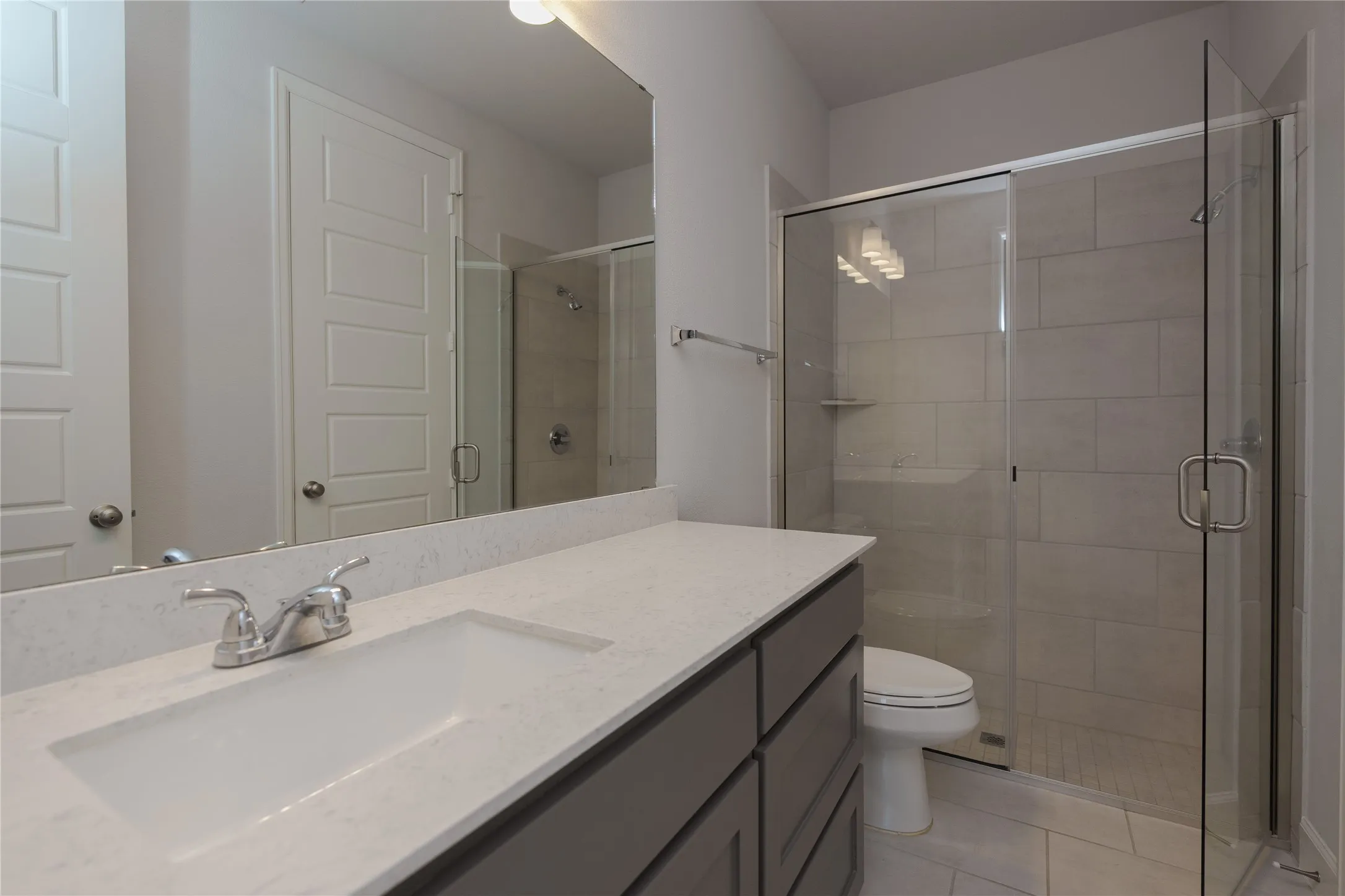 Vanity with an integrated sink, polished chrome faucet, and stone-finish countertop