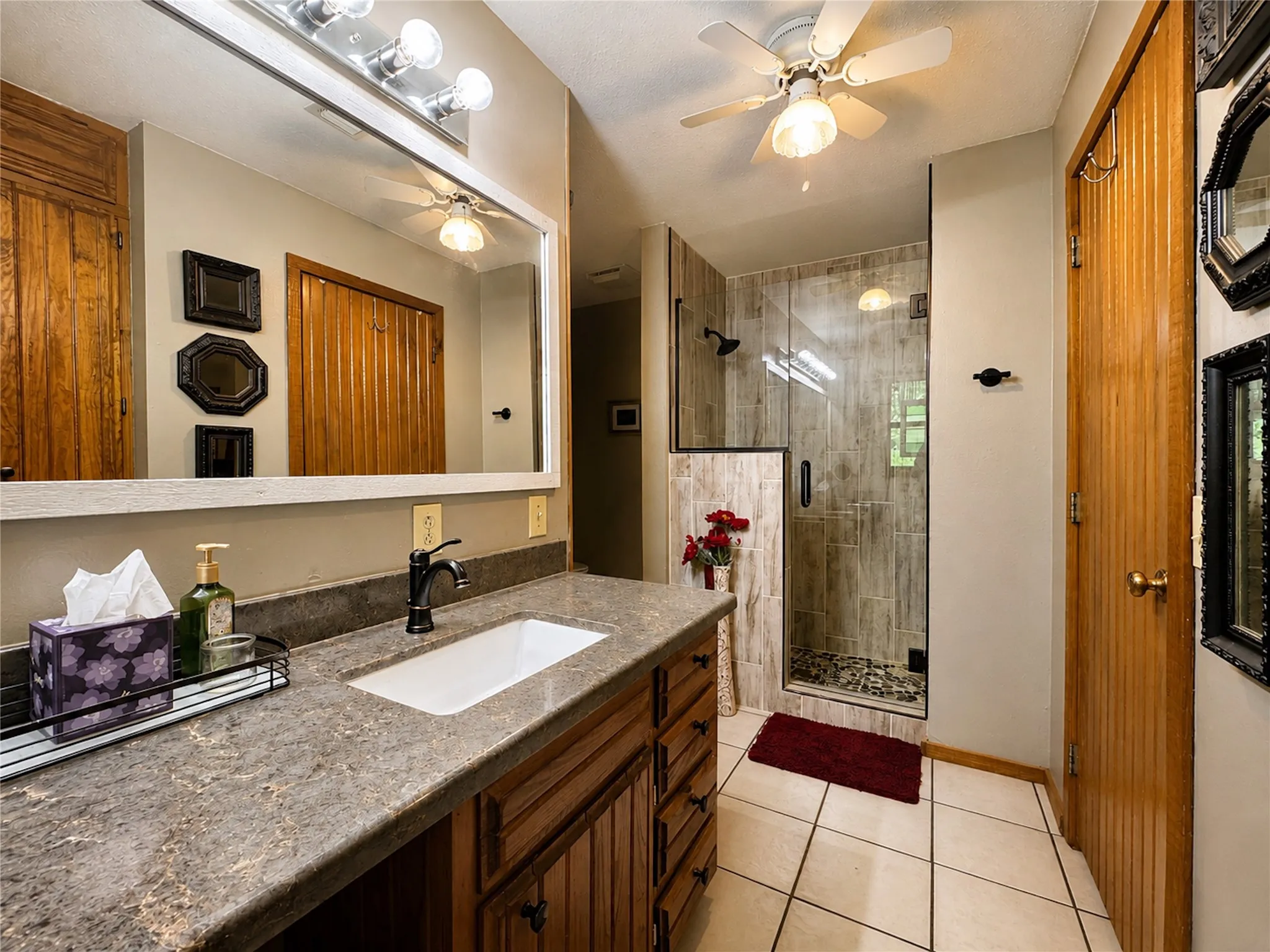 Vanity with a stone countertop, an undermount sink, and a matte black faucet