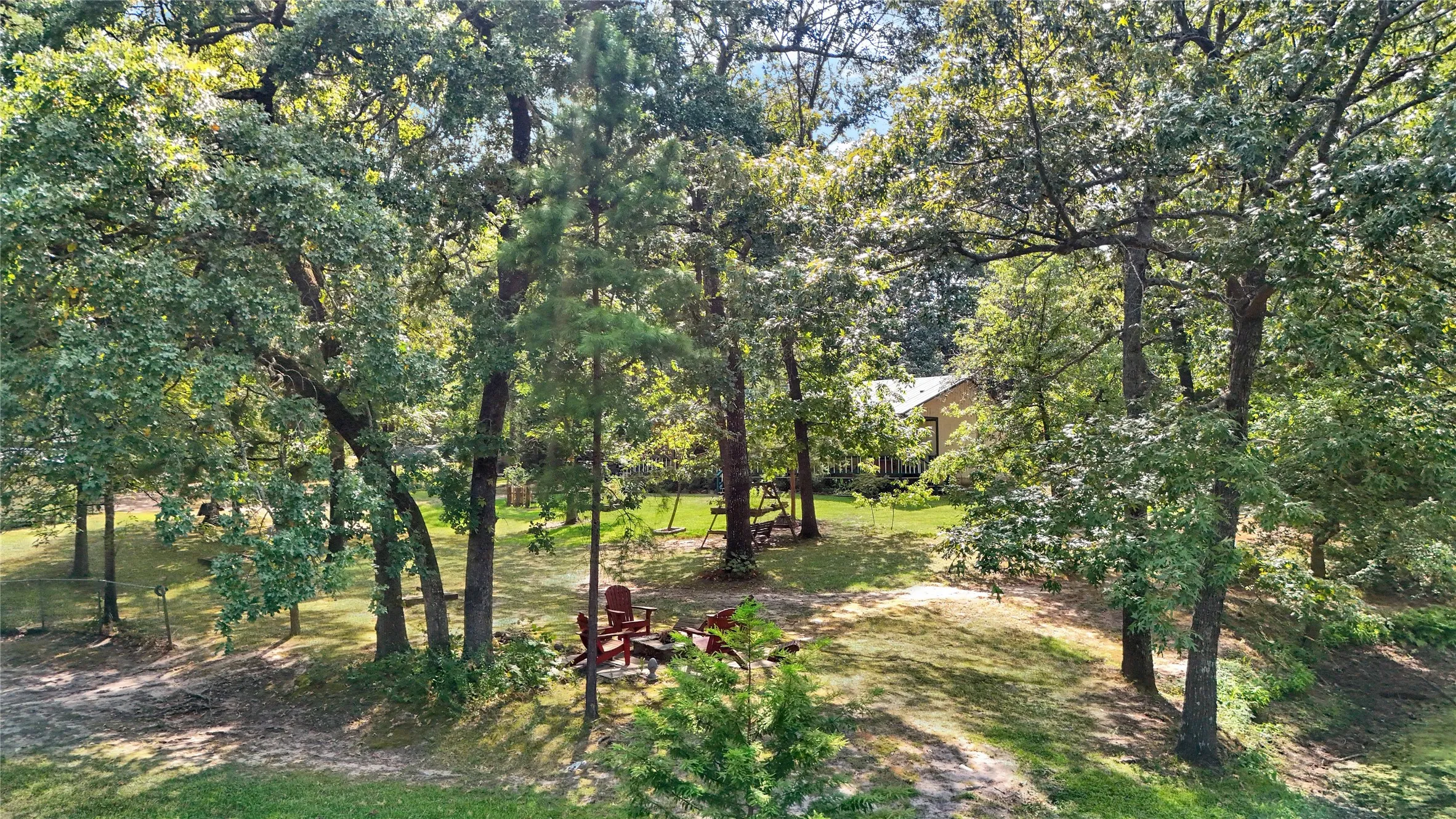 Expansive wooded property featuring mature trees and a manicured lawn