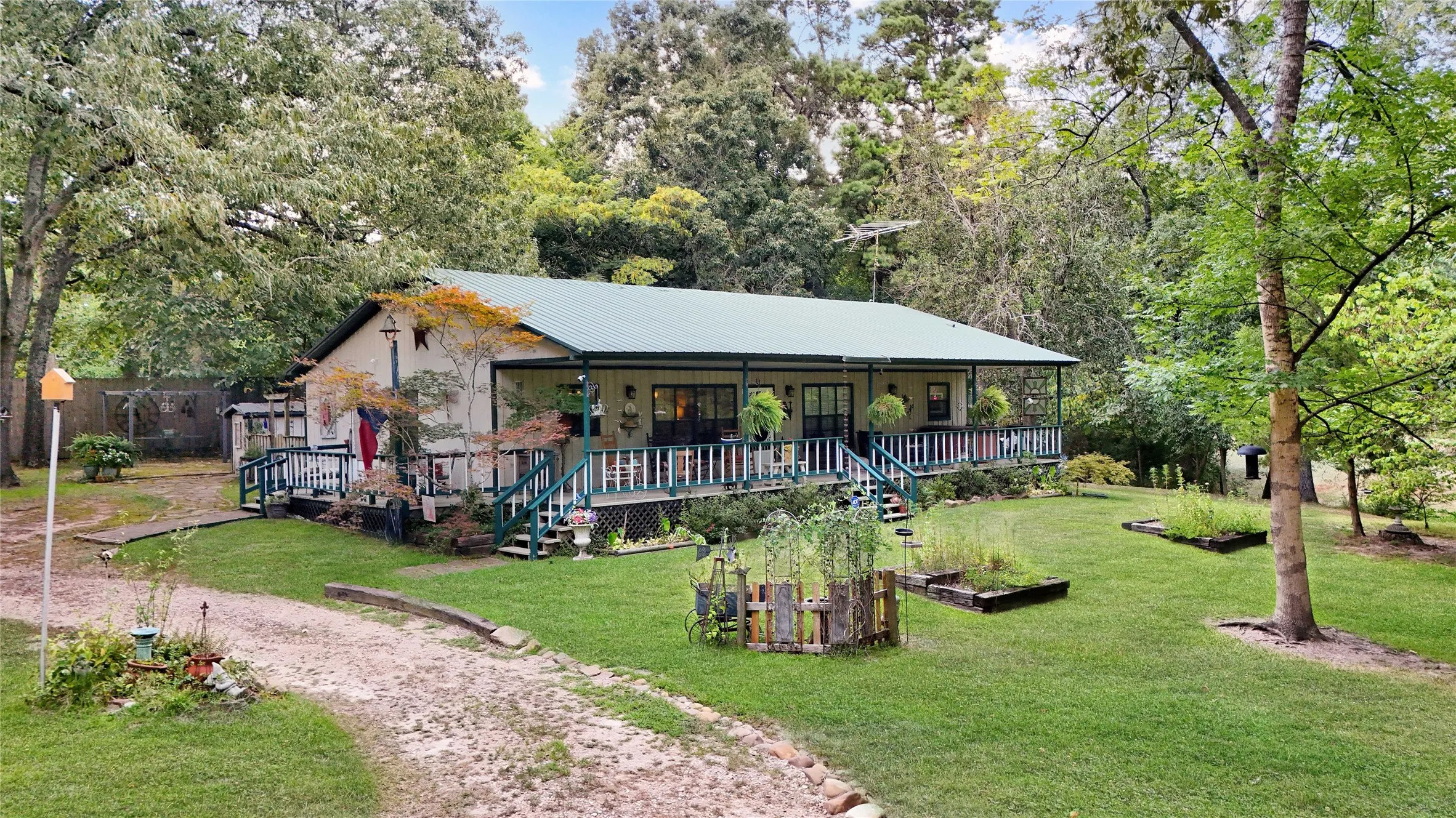 Single-story residence featuring a green metal roof and a full-length covered porch with white railings
