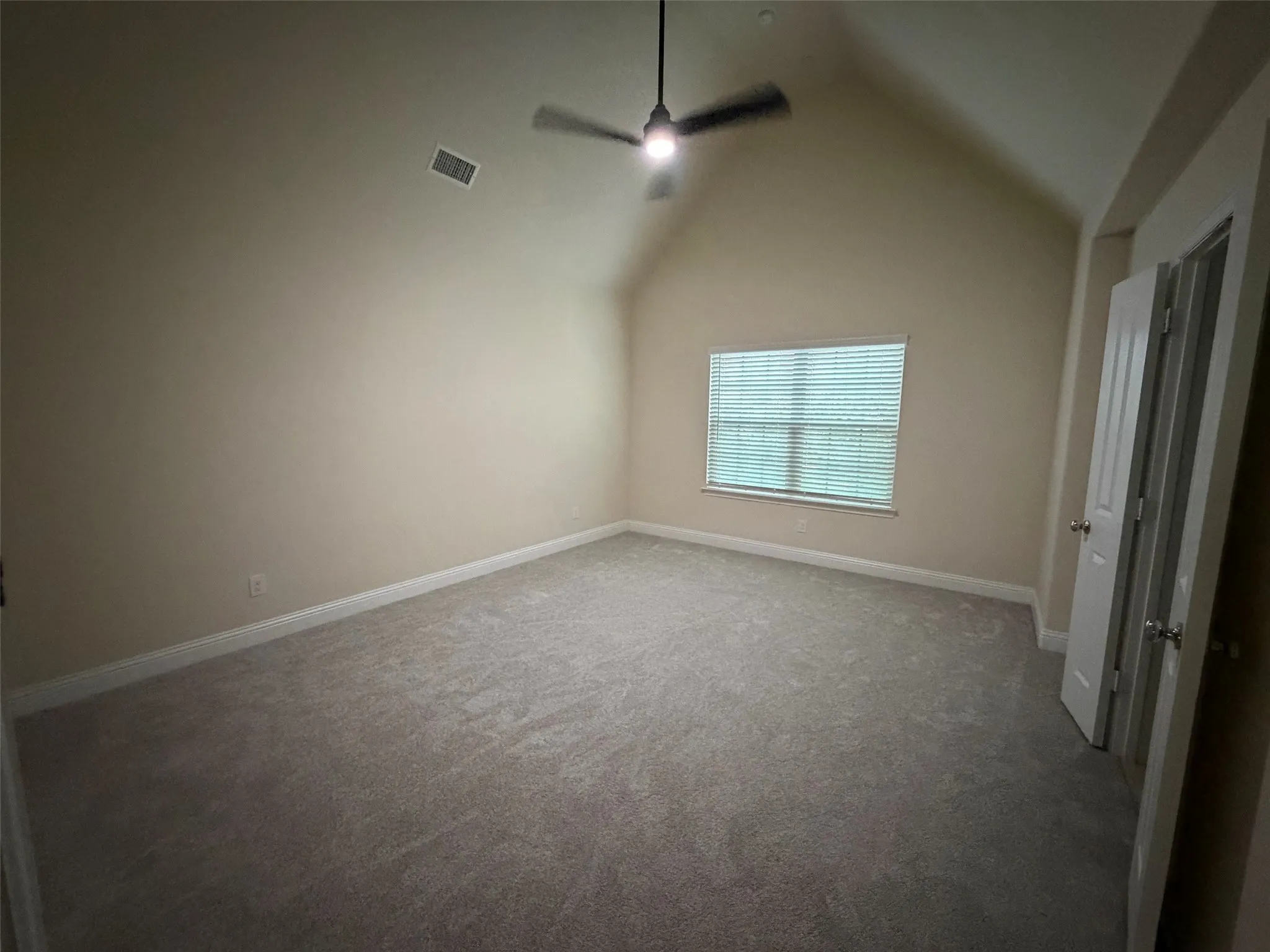 Primary bedroom with high ceilings and ceiling fan