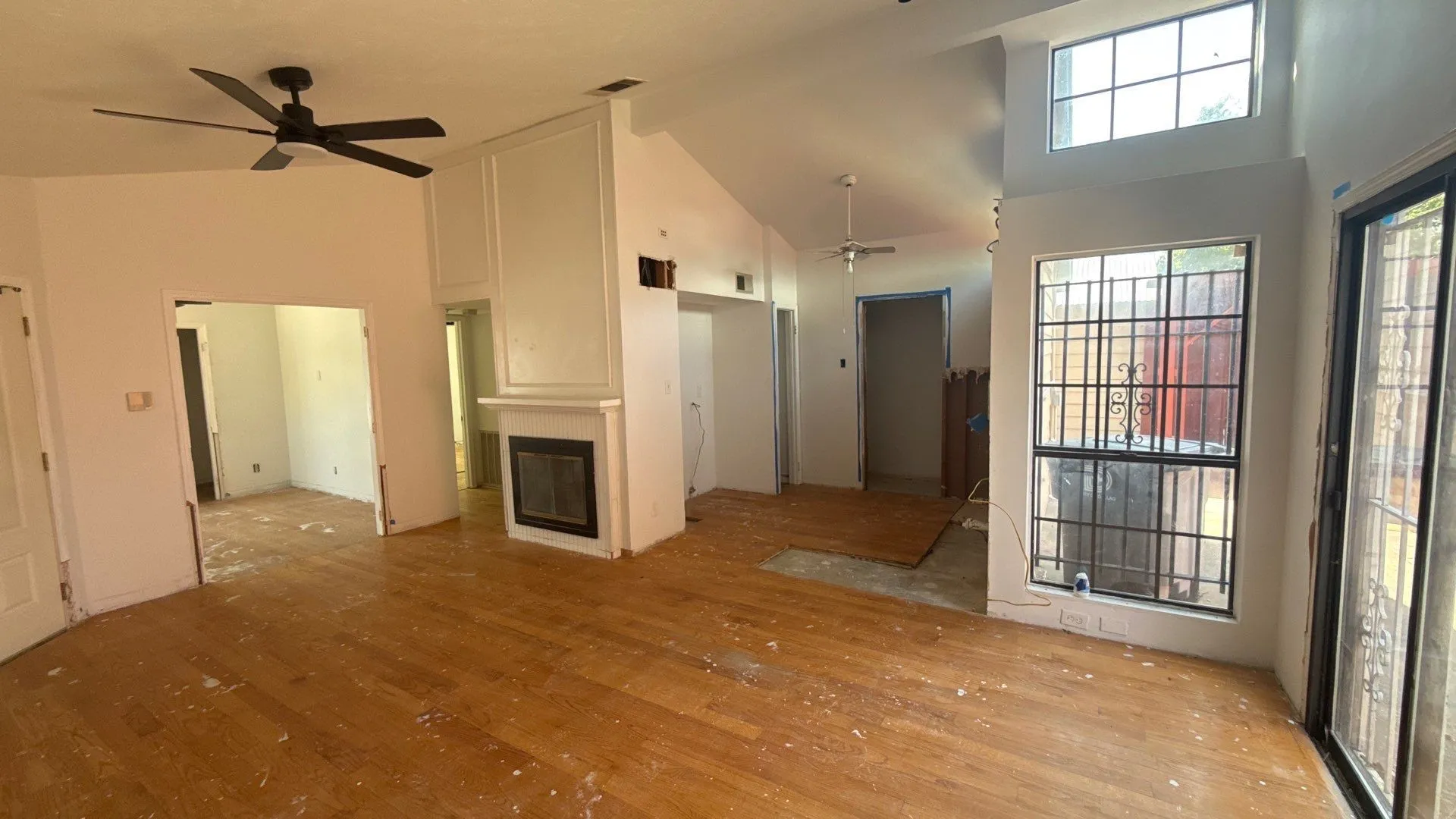 Vaulted ceilings, wood-finish flooring, built-in fireplace, and expansive windows