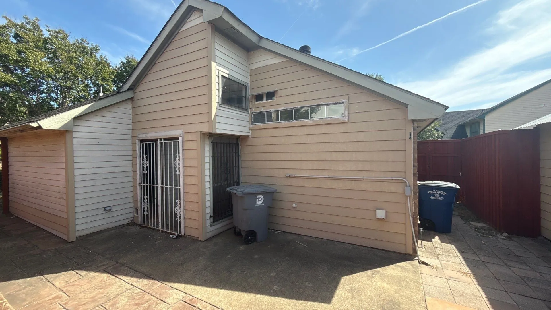 Exterior with horizontal siding, a pitched roof, and a red privacy fence