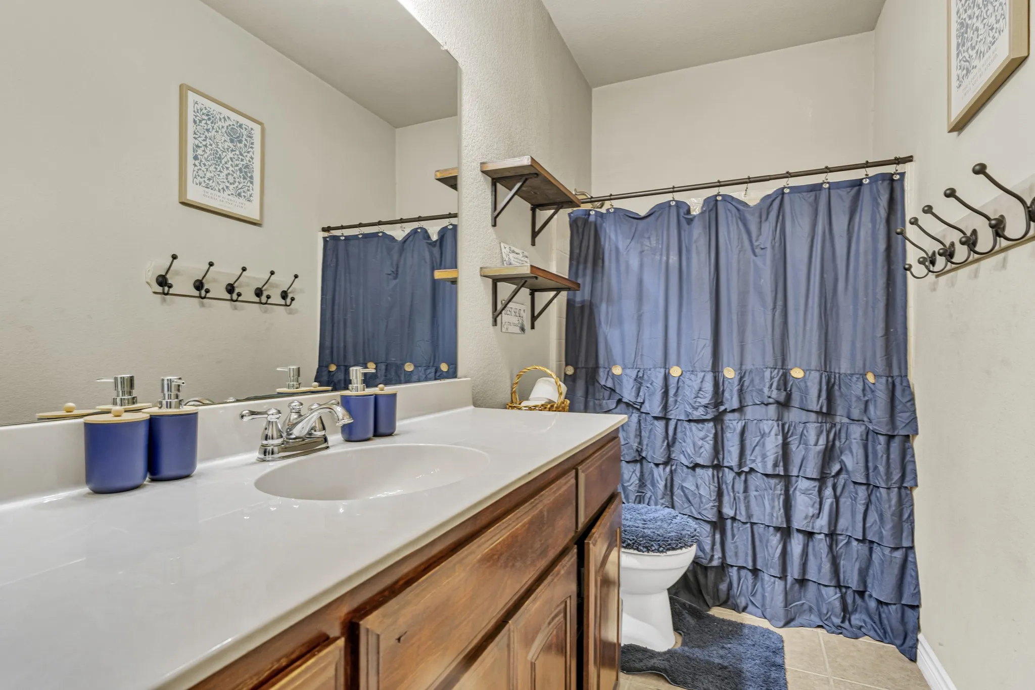 Vanity with integrated sink, wood-finish cabinetry, and chrome fixtures