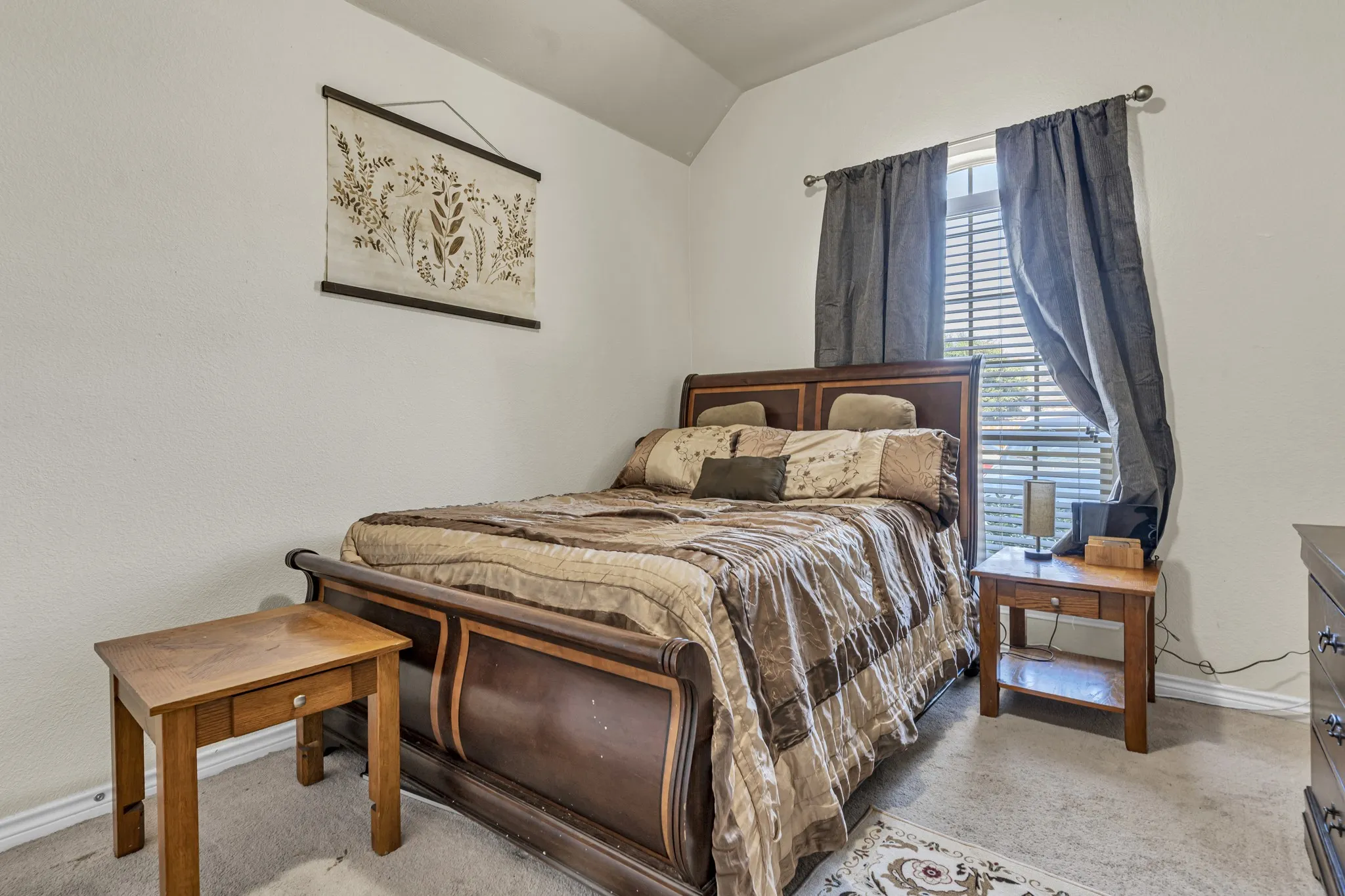 Bedroom with vaulted ceiling, window with blinds, and carpeted flooring
