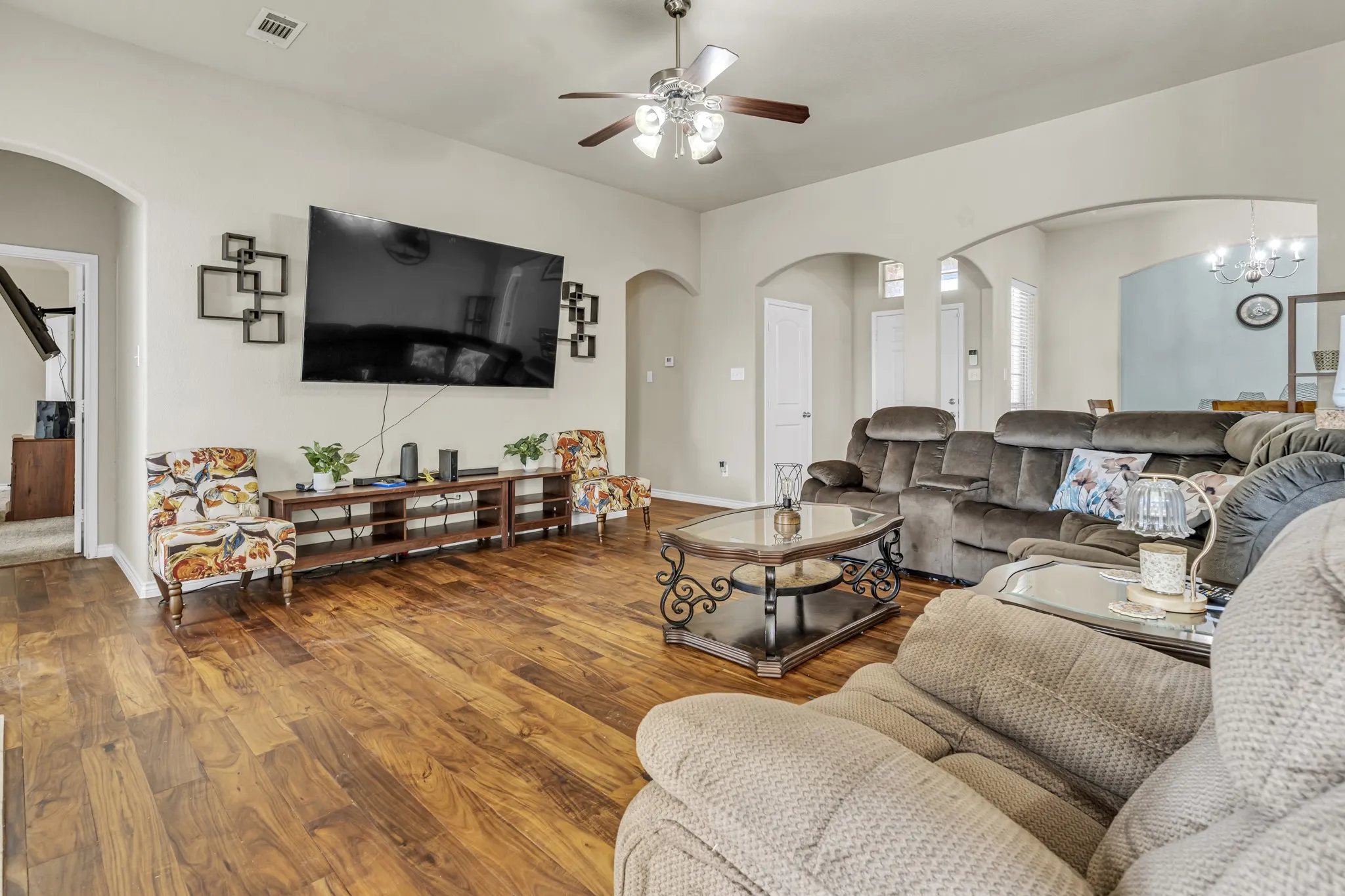 Wood-finish flooring throughout, light neutral wall color, and arched doorways