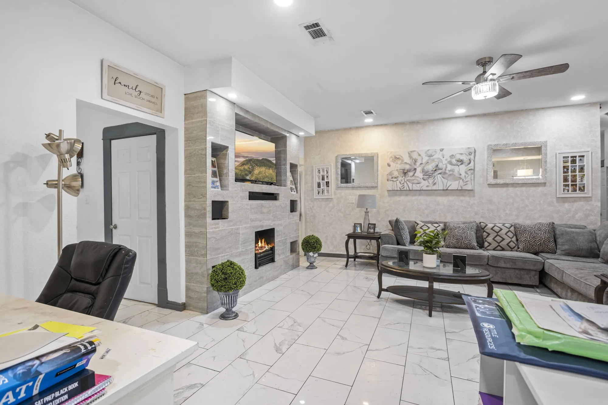 Living room featuring light marble finish floors, a ceiling fan, a tiled fireplace, and recessed lighting