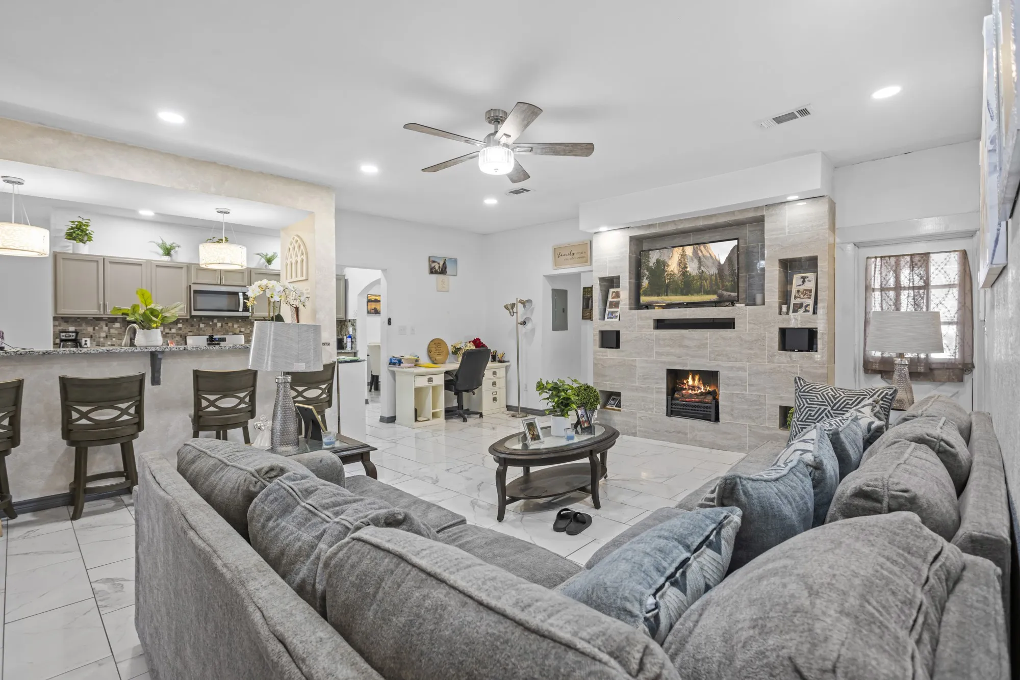 Living area with light marble finish floors, a fireplace, a ceiling fan, and recessed lighting