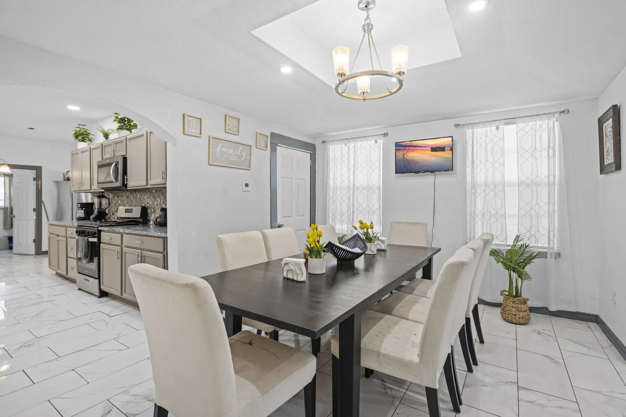 Dining space with light marble finish floors, recessed lighting, arched walkways, and a chandelier