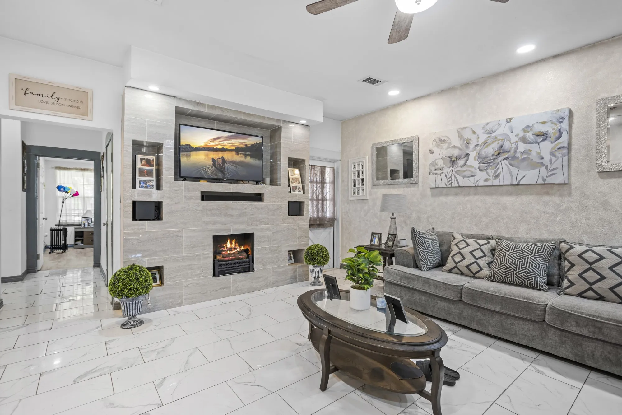 Living area featuring a tiled fireplace, ceiling fan, marble finish flooring, and recessed lighting