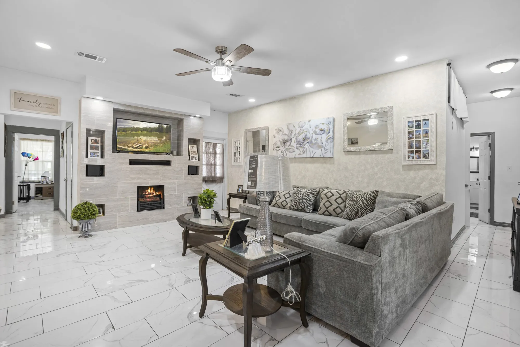 Living area featuring ceiling fan, light marble finish flooring, a fireplace, and recessed lighting