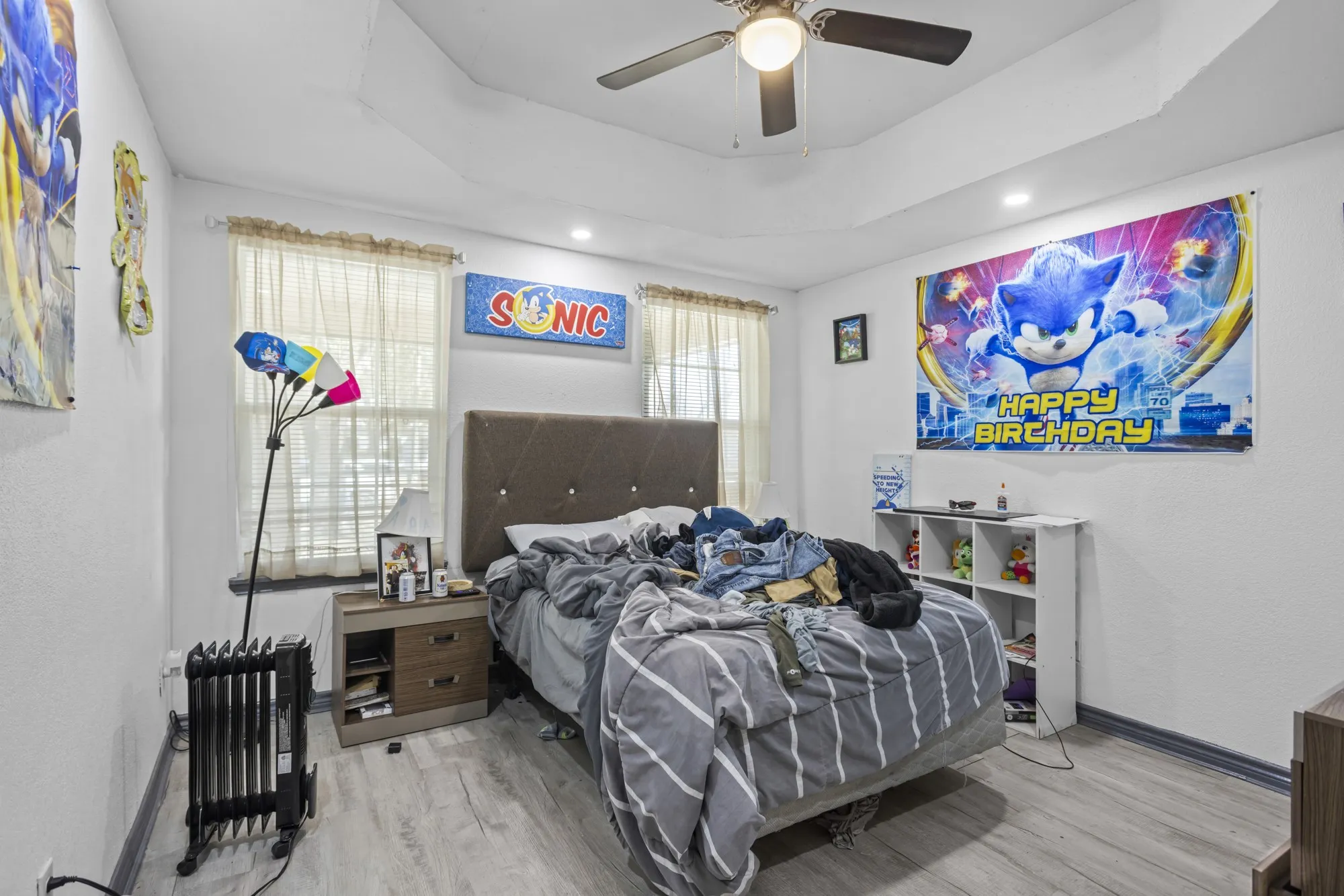 Bedroom featuring wood finished floors, a tray ceiling, recessed lighting, and ceiling fan