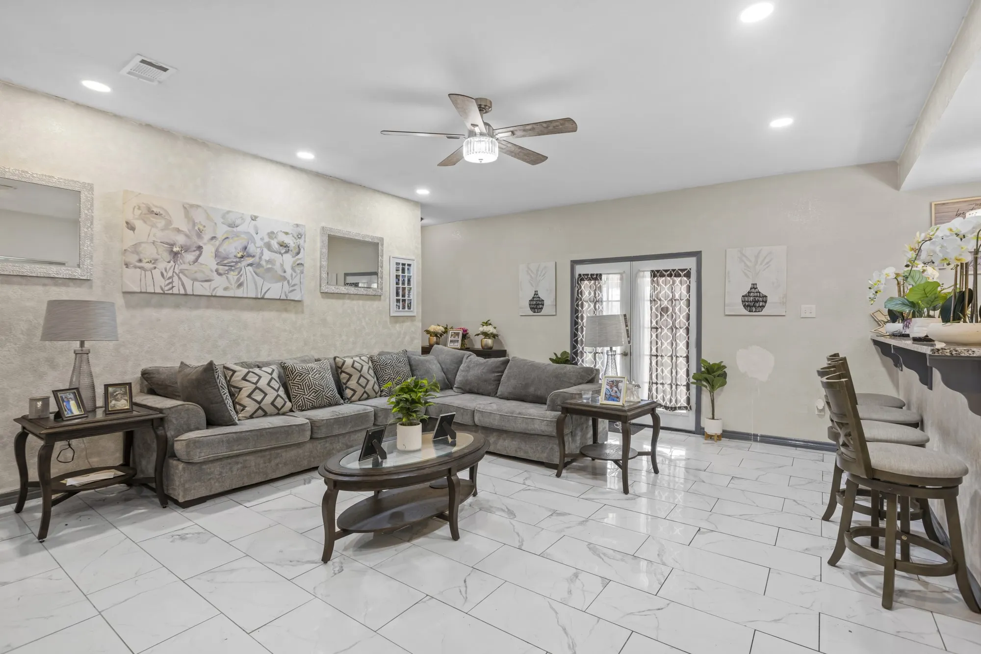 Living room with light marble finish floors, a ceiling fan, and recessed lighting