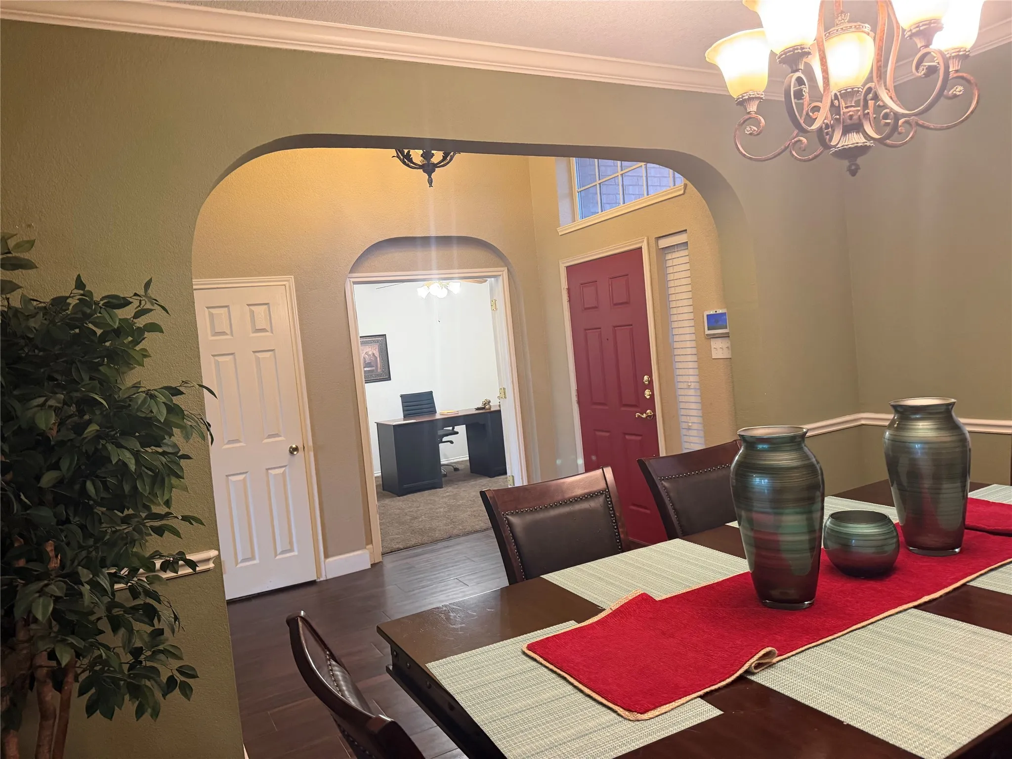 Formal dining room featuring wood-finish flooring, an ornate chandelier, and crown molding