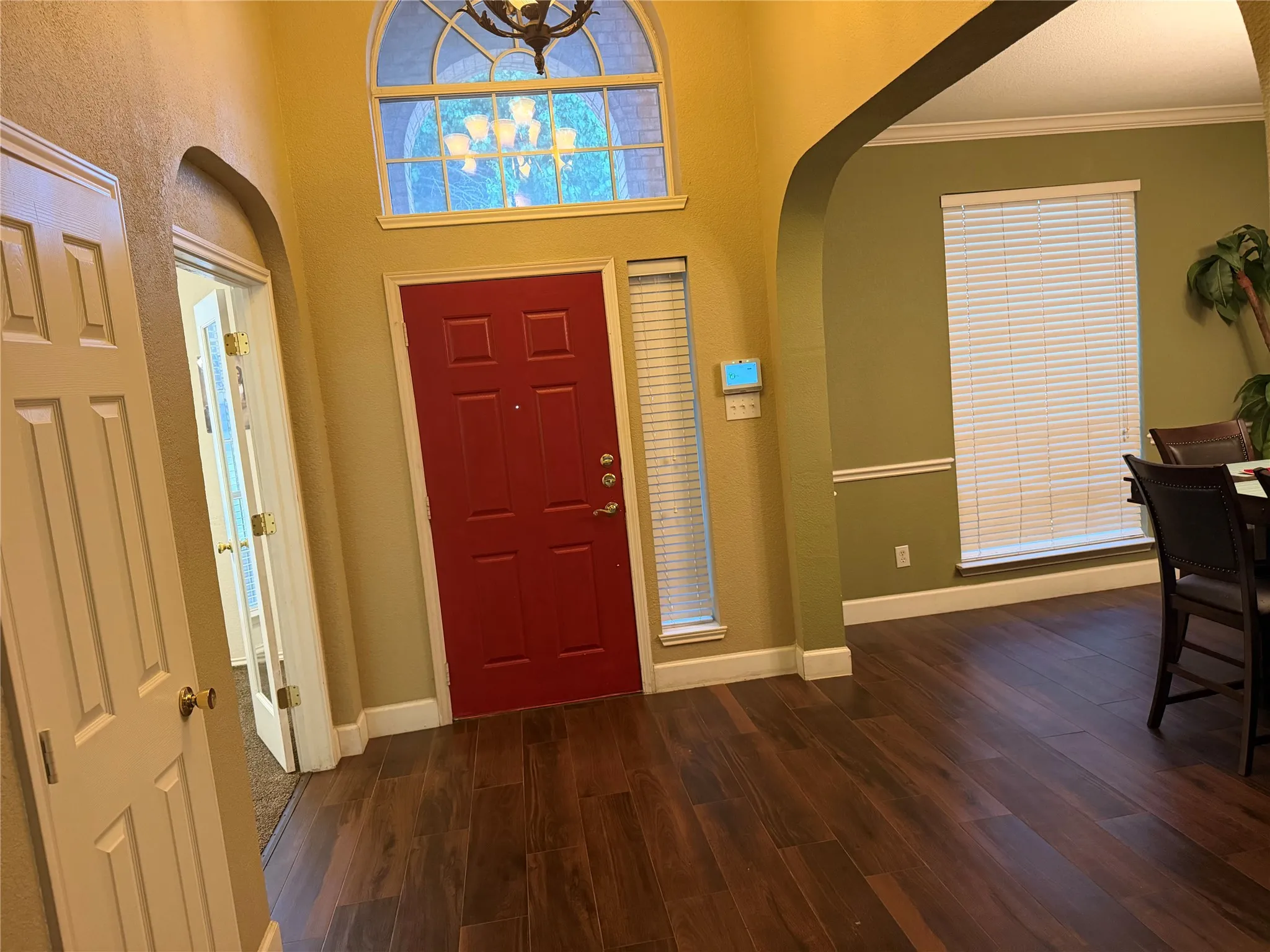 Arched entry with a prominent red door and sidelight window