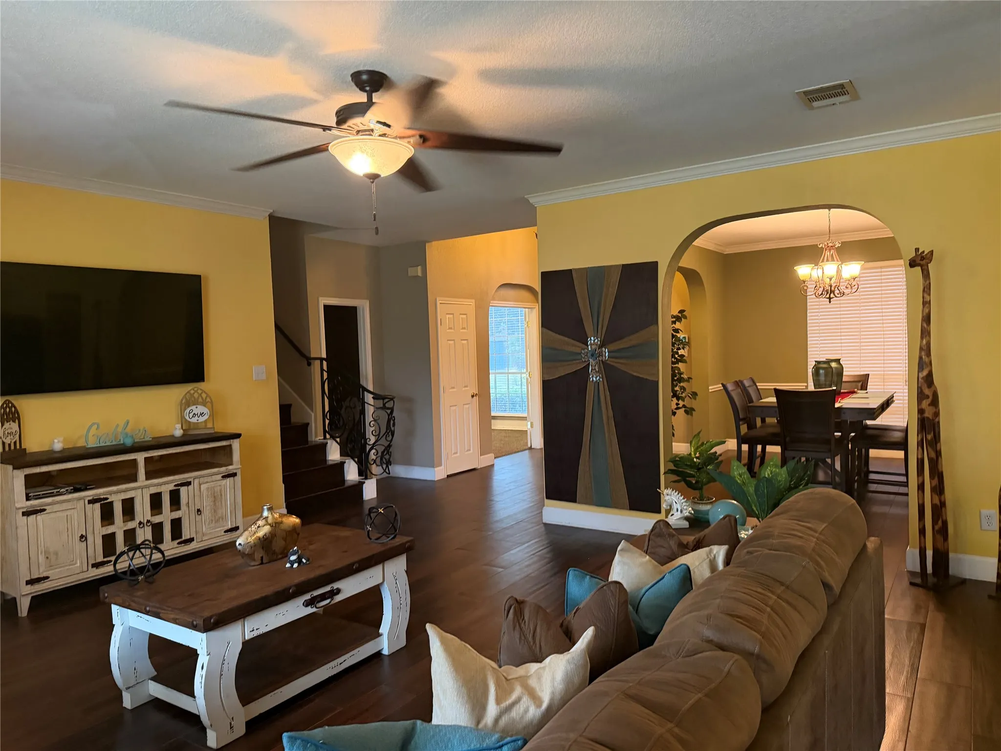 Hardwood-finish flooring, crown molding, and an arched doorway