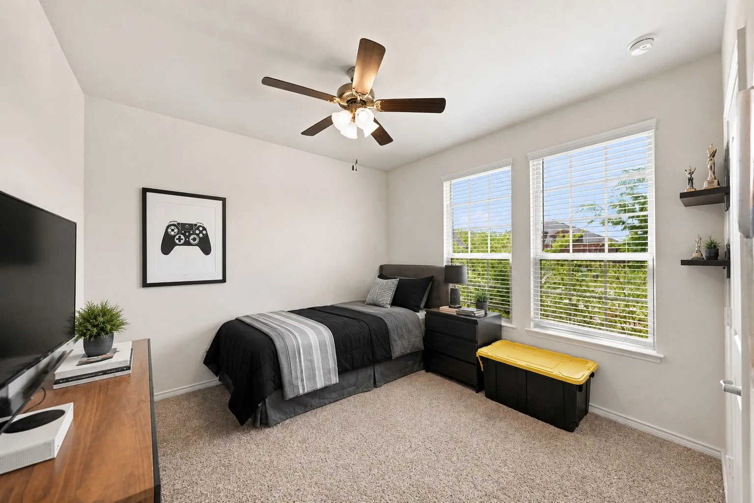 Neutral wall paint, carpet flooring, a ceiling fan with integrated lighting, and two windows with blinds