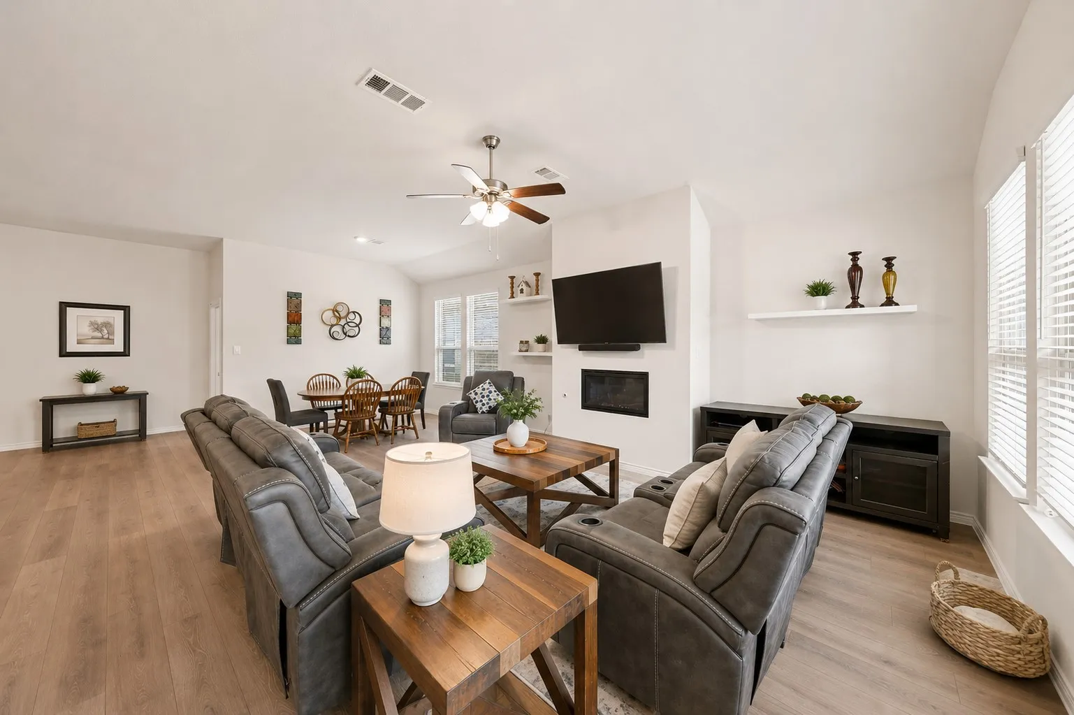 Vaulted ceiling with a ceiling fan, wood-finish flooring, recessed lighting, and a built-in fireplace