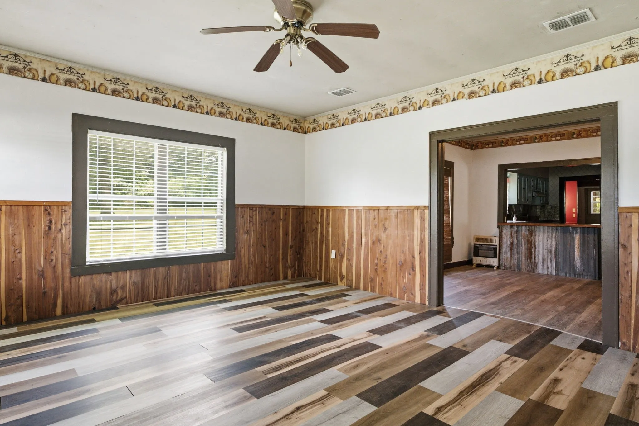 Wood-finish flooring, wood paneling, and an overhead ceiling fan