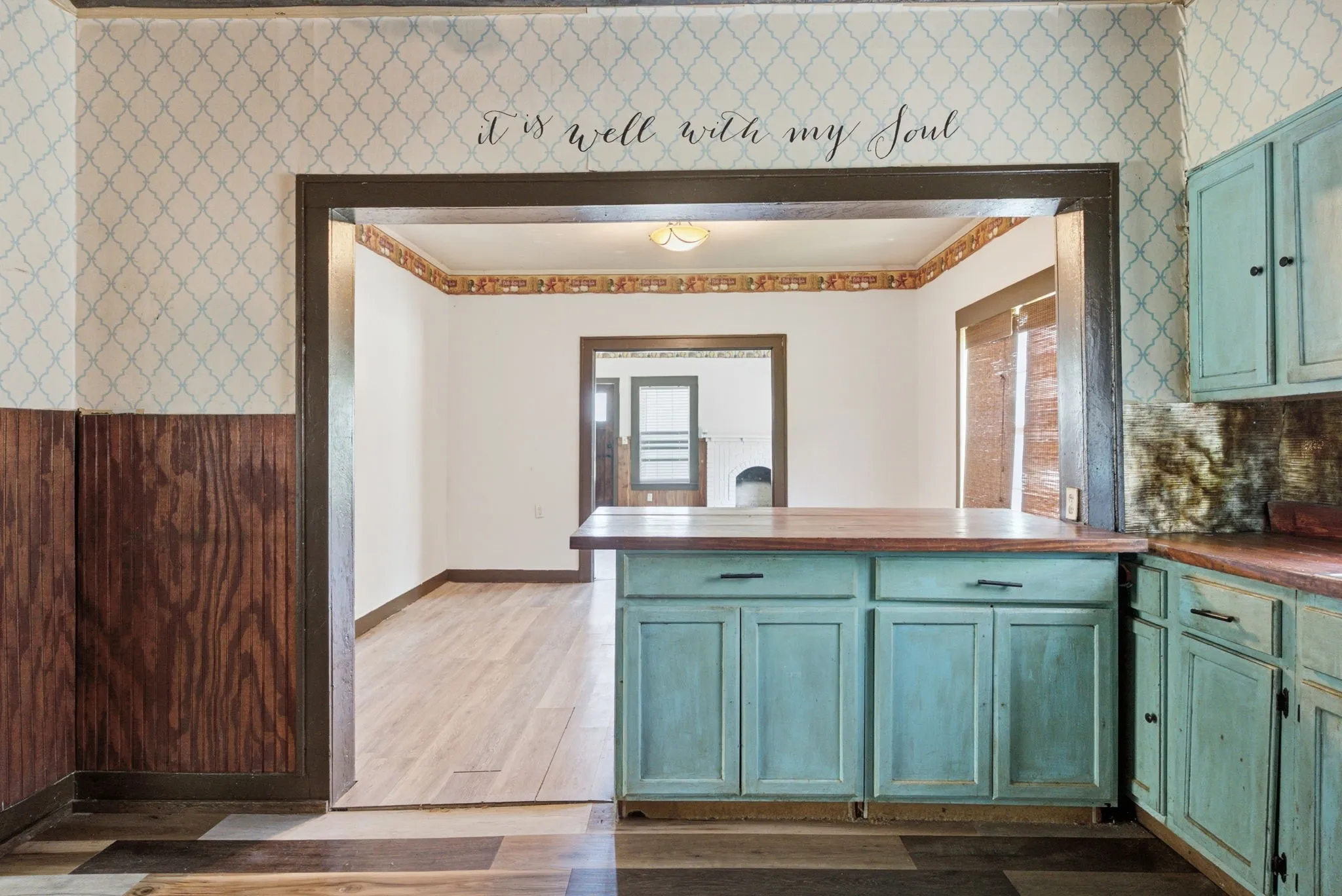 Wood-finish flooring throughout, complemented by a distressed wood-look island with a wood countertop