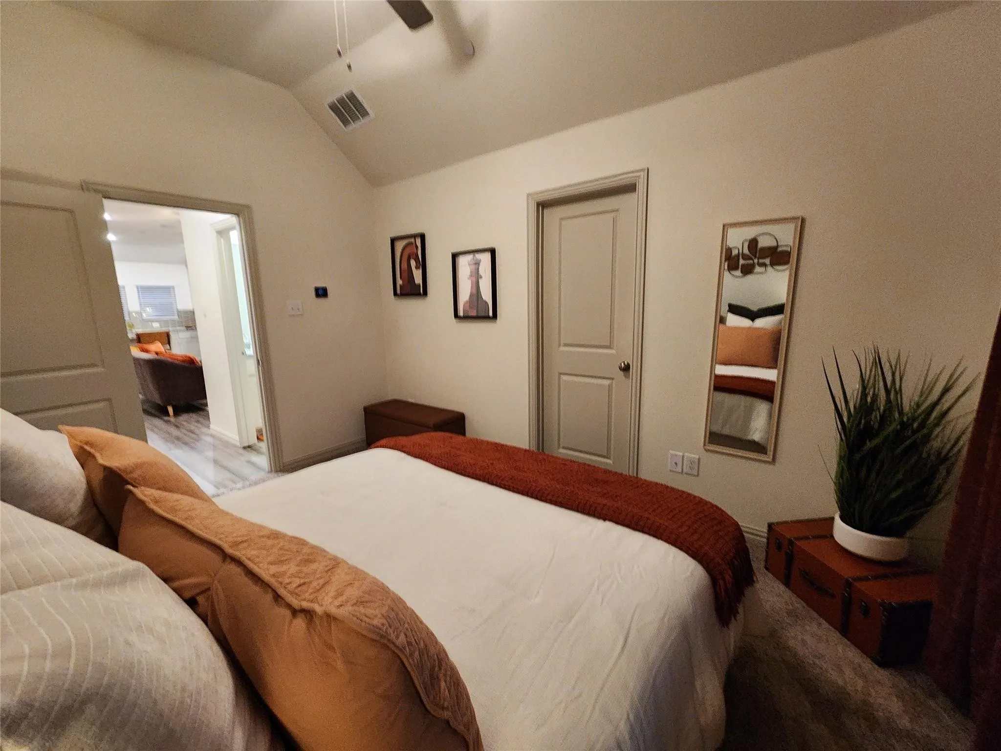 Vaulted ceiling with ceiling fan, light gray wall paint, and wood-finish flooring