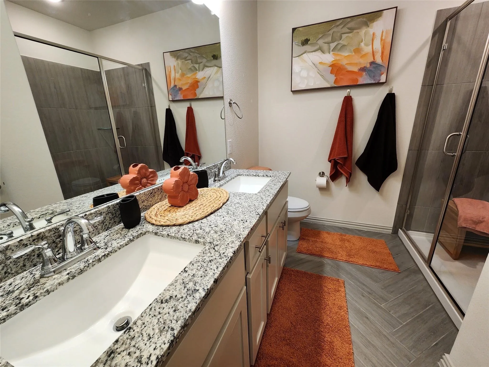Dual vanity with granite countertops, chrome fixtures, and undermount sinks