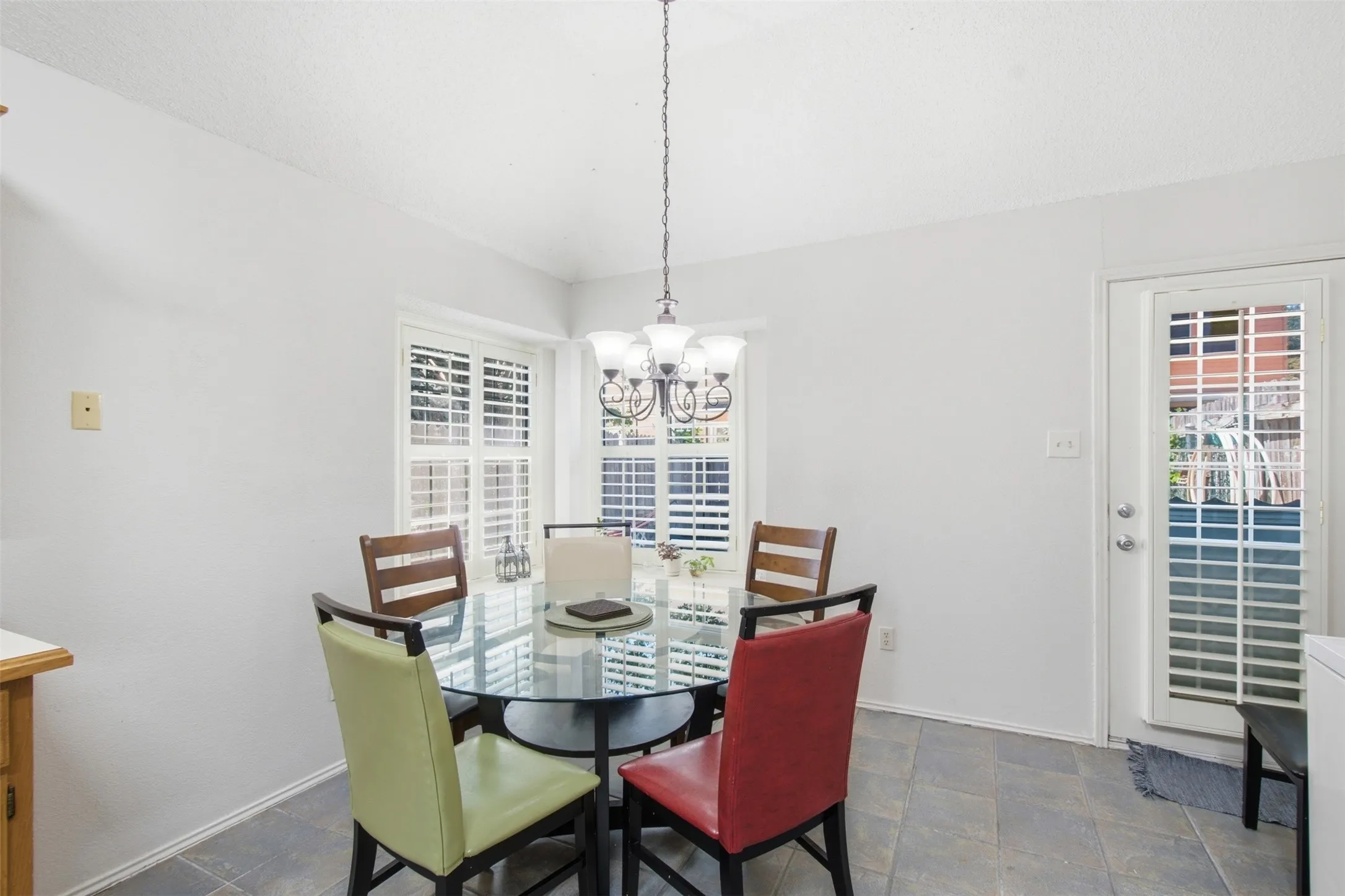 White walls, tile flooring, and a glass-paneled door