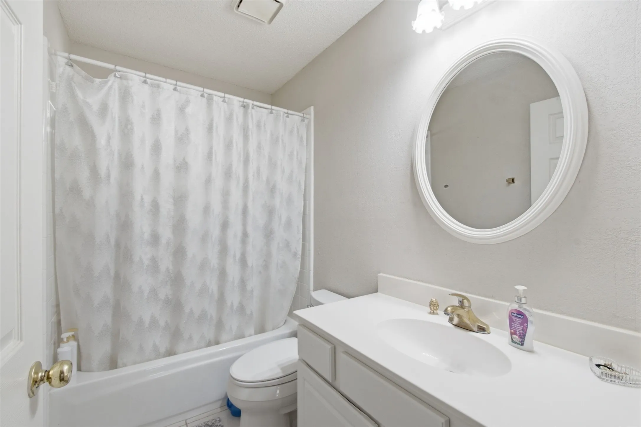 White vanity with an integrated sink and brass-finish faucet