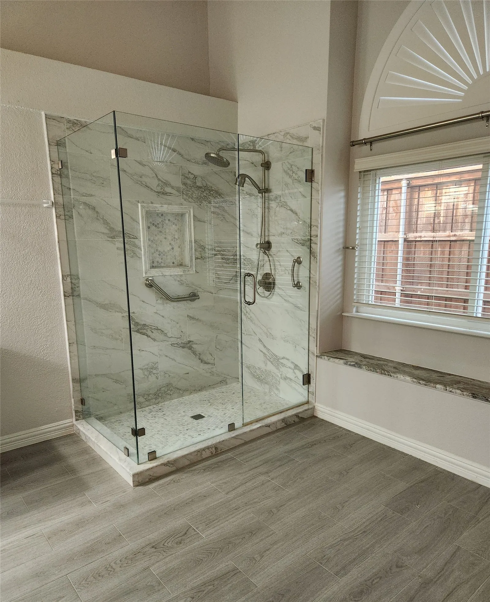Primary bath with large standup shower and granite sitting ledge