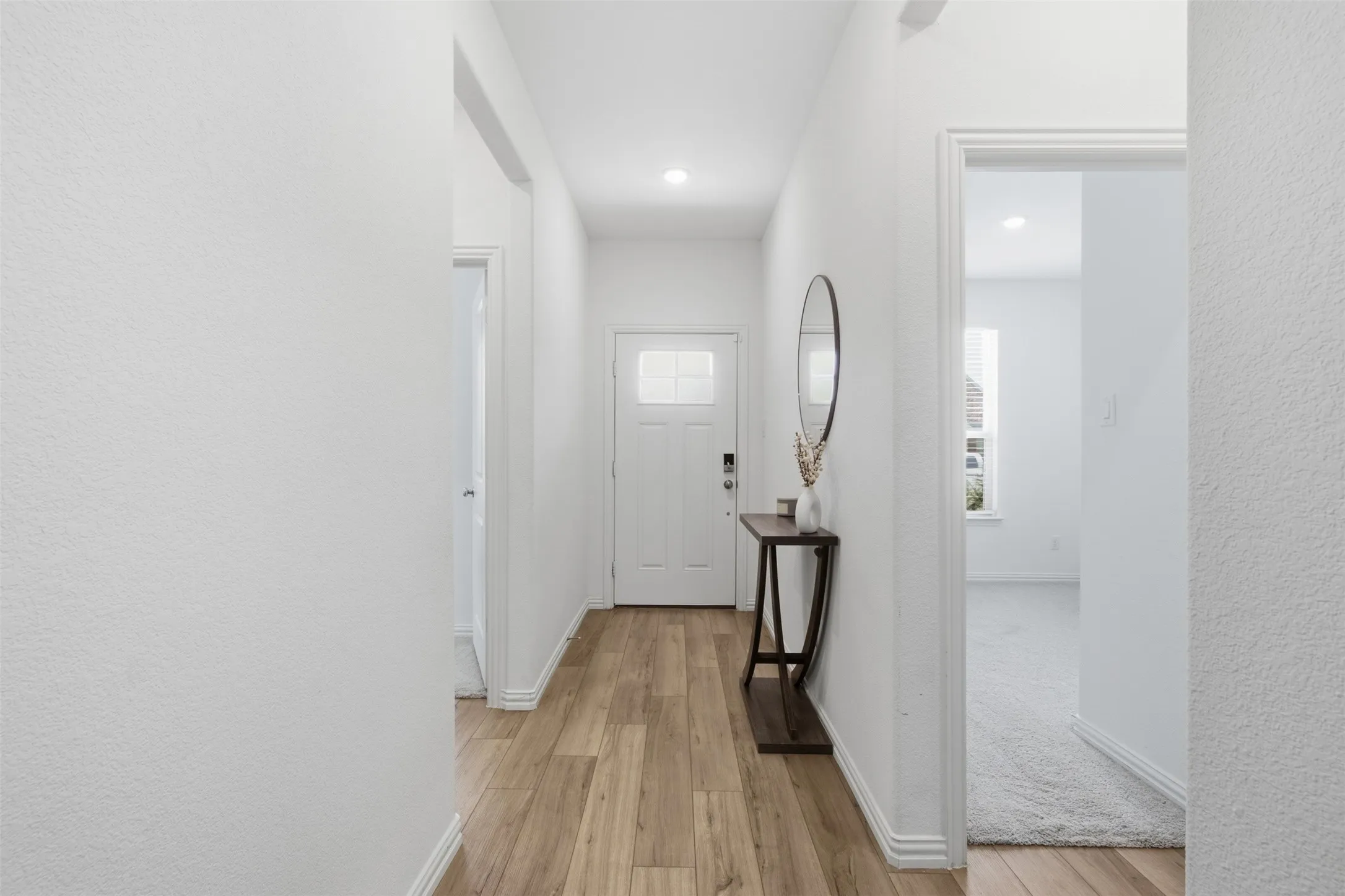 Entry with 2 bedrooms and a full bath to the left and a third bedroom or office space located to the right.
