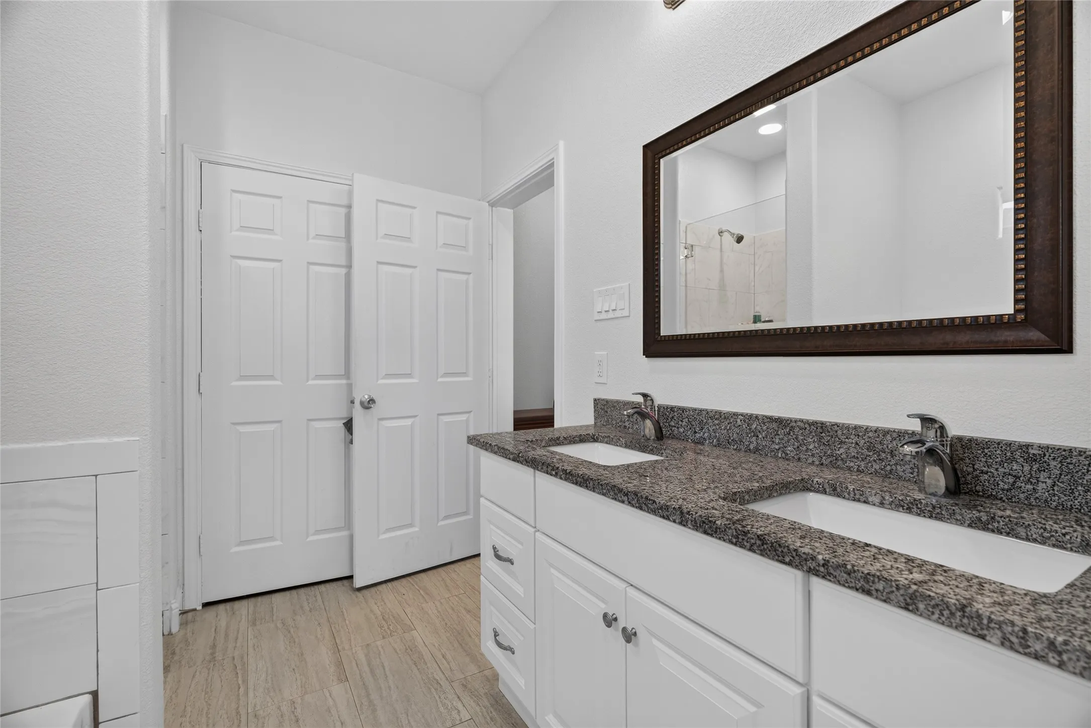 Dual vanity with undermount sinks, granite countertops, and chrome fixtures
