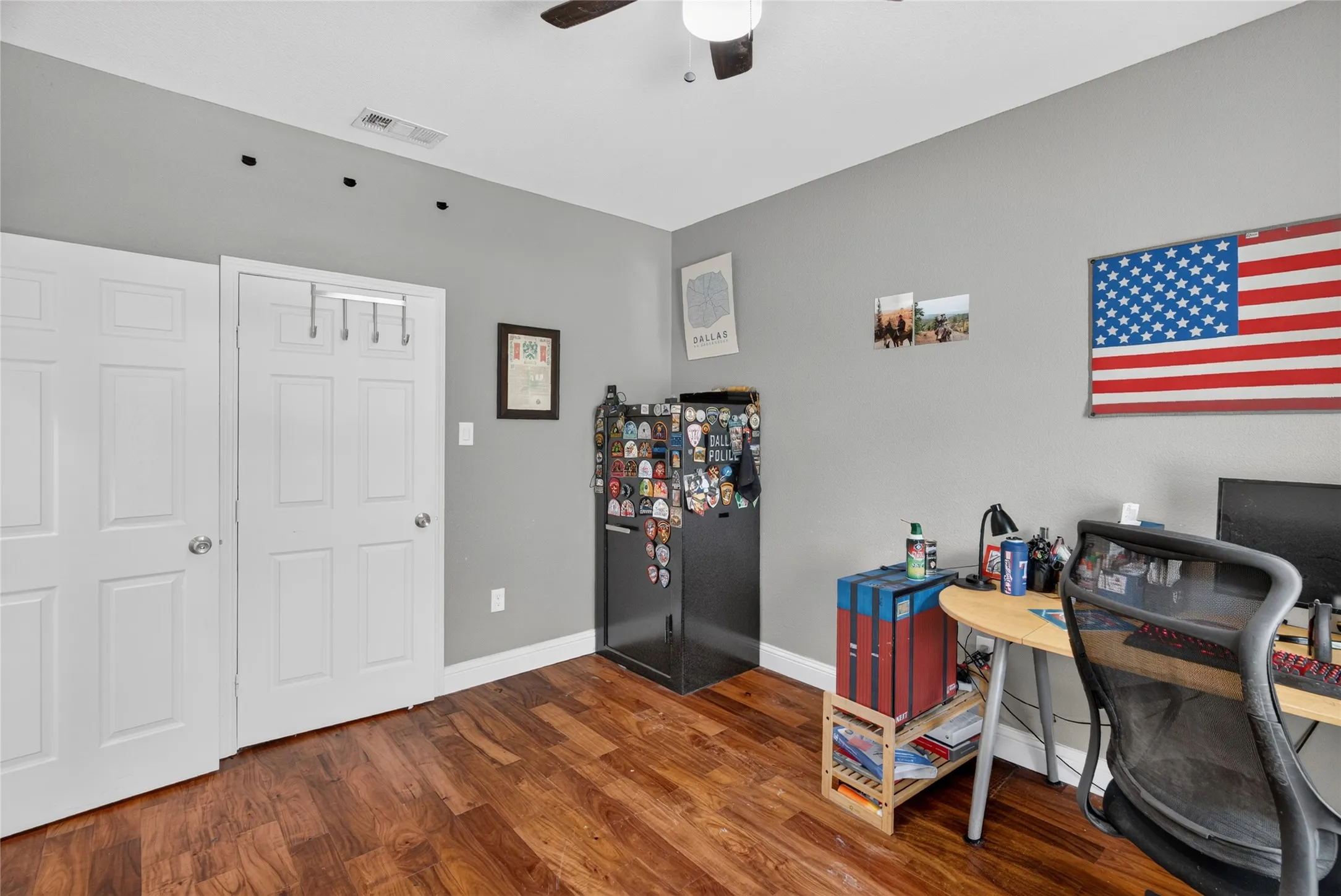 Wood-finish flooring, white paneled doors, ceiling fan with integrated lighting, and neutral wall tones