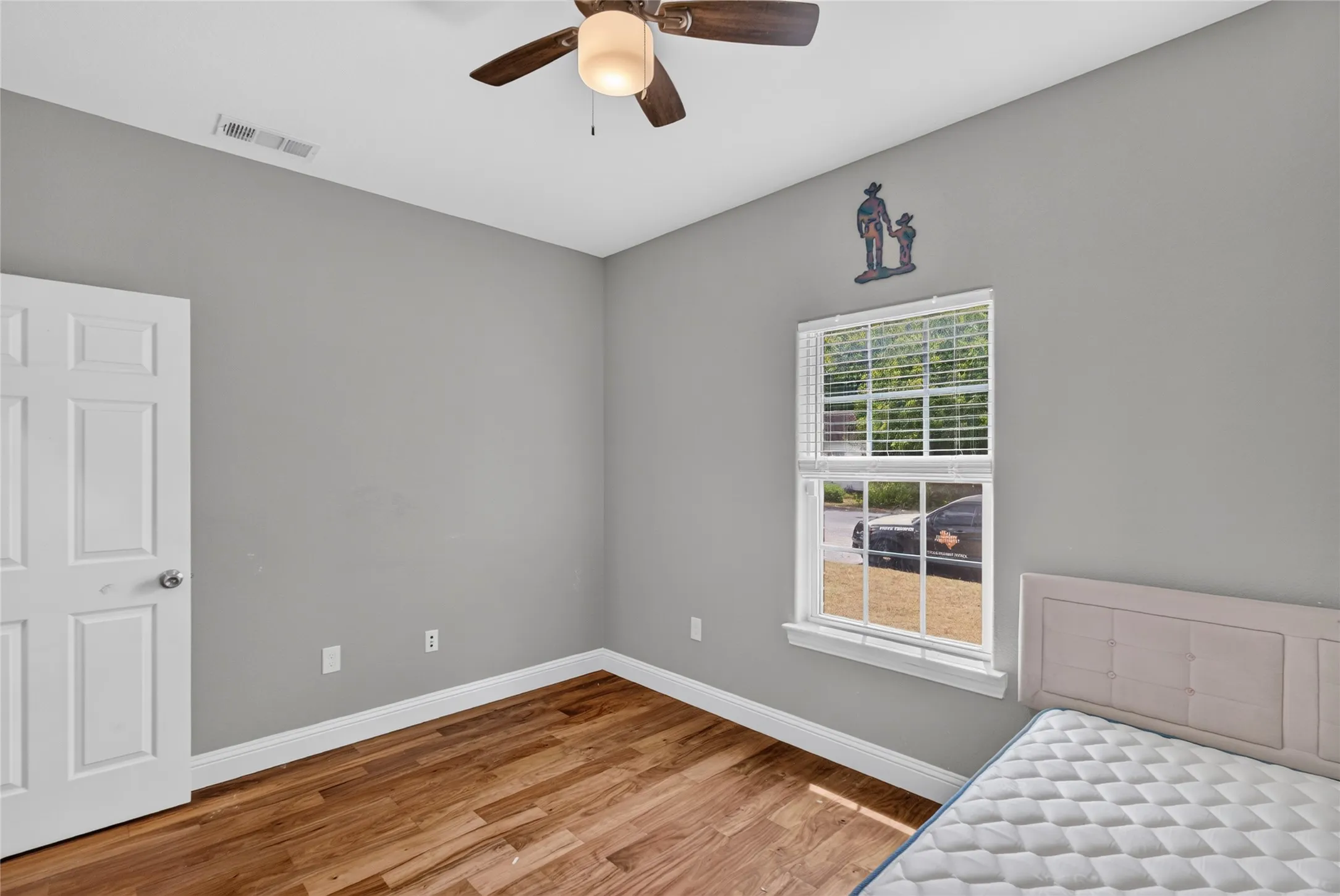 Wood-finish flooring, white trim, and light gray walls