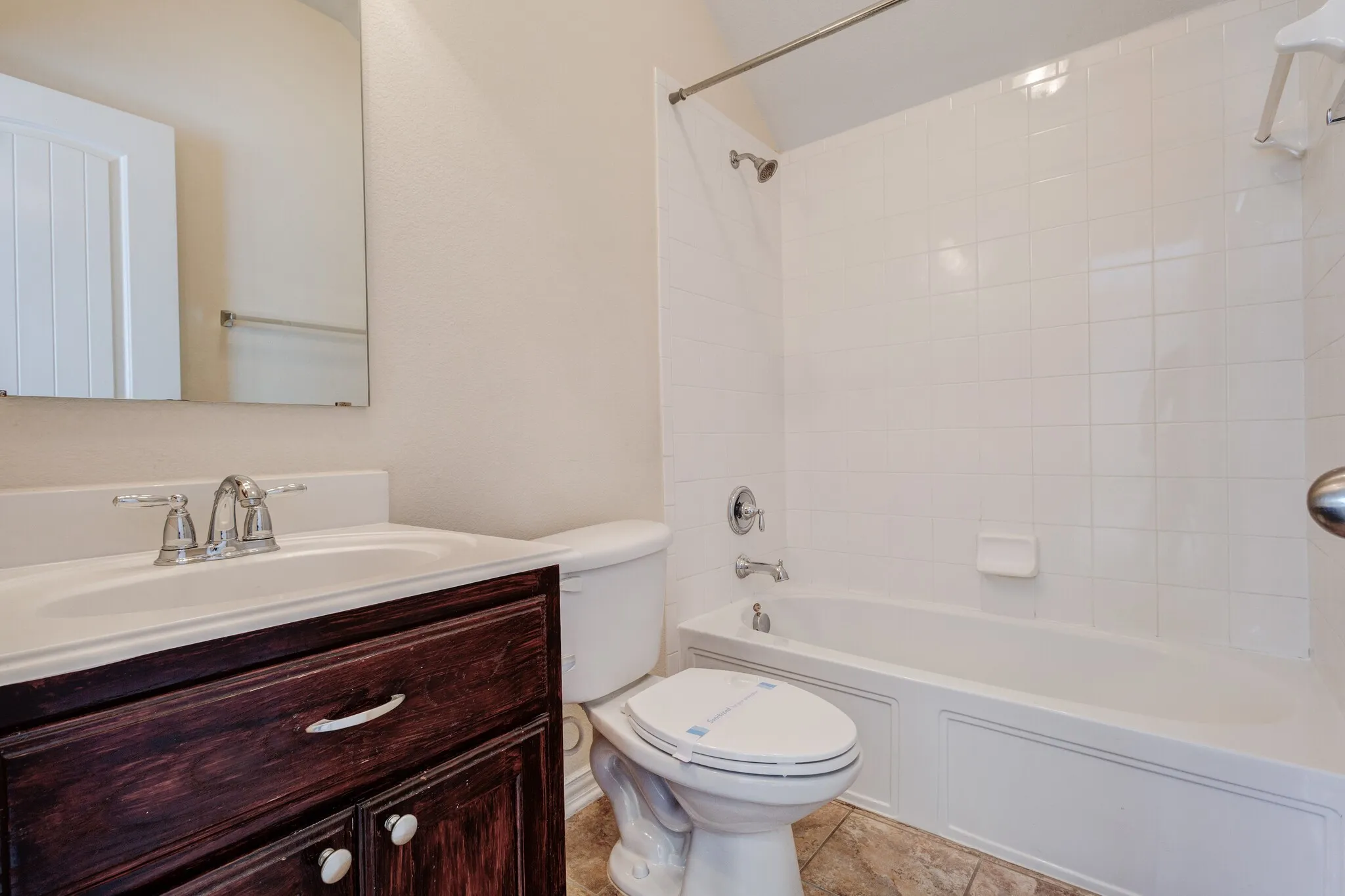 Bathroom featuring a vanity with dark wood-finish cabinetry, white countertop, and integrated sink