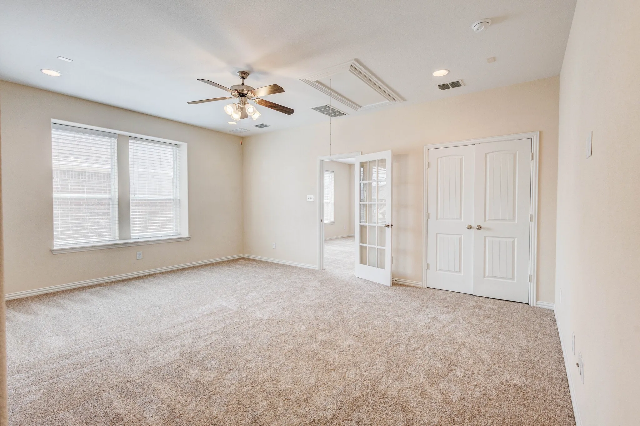 Recessed lighting, ceiling fan, neutral carpet, French doors, double panel doors