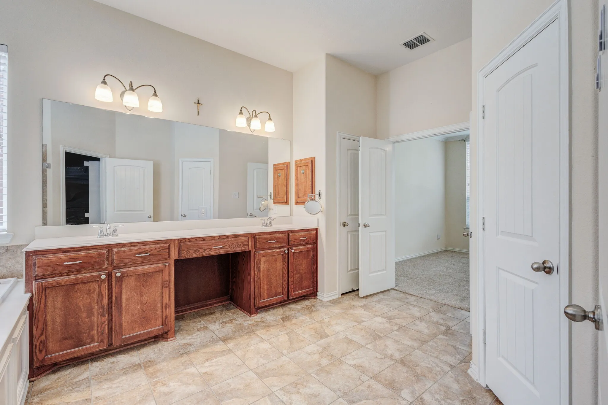 Dual vanity with wood-finish cabinetry, a lengthy countertop, and integrated sinks