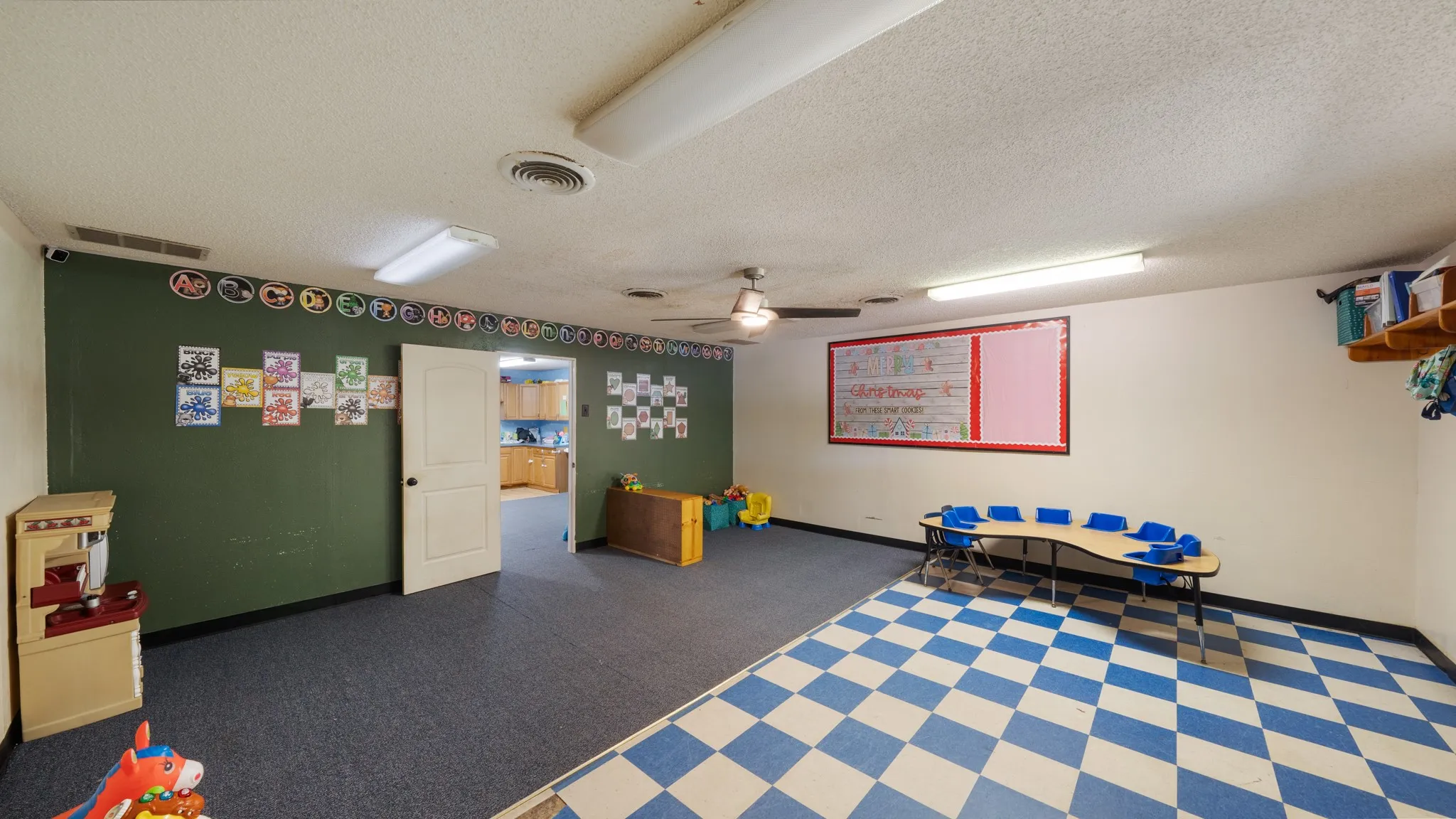 Spacious interior room with mixed flooring, including blue checkered and blue carpet