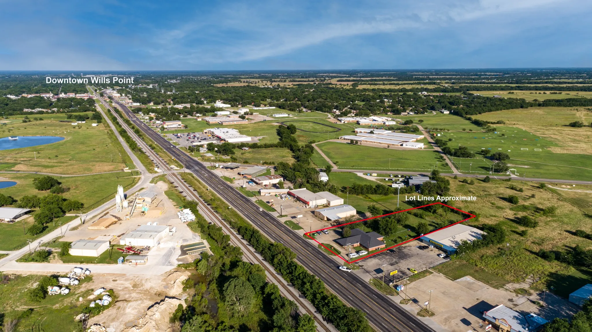 Aerial view of a commercial property featuring a flat roof structure and an adjacent parking area