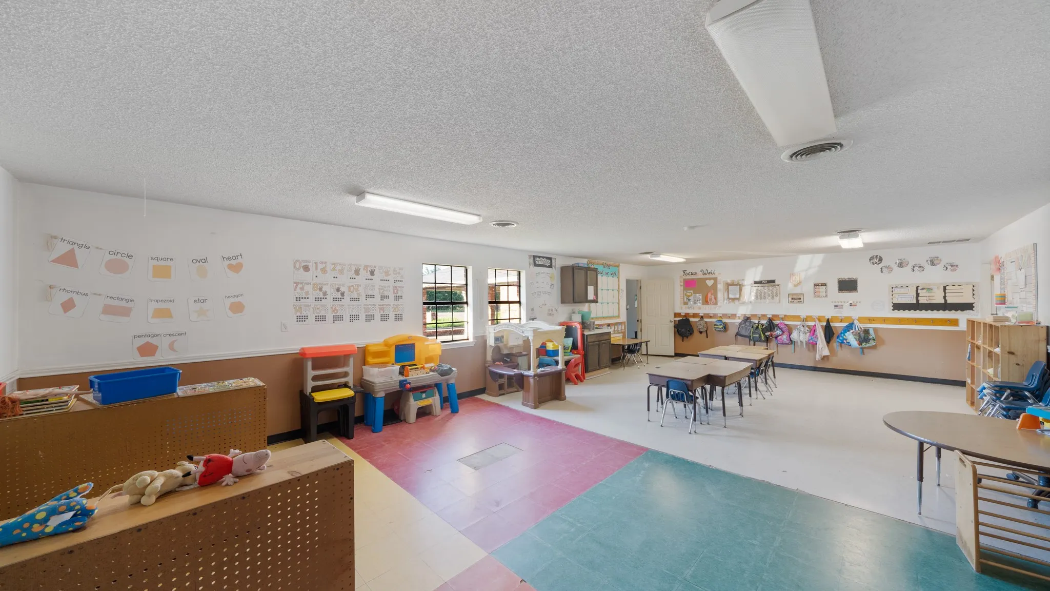 Spacious interior with multiple windows providing natural light, durable flooring, and built-in shelving