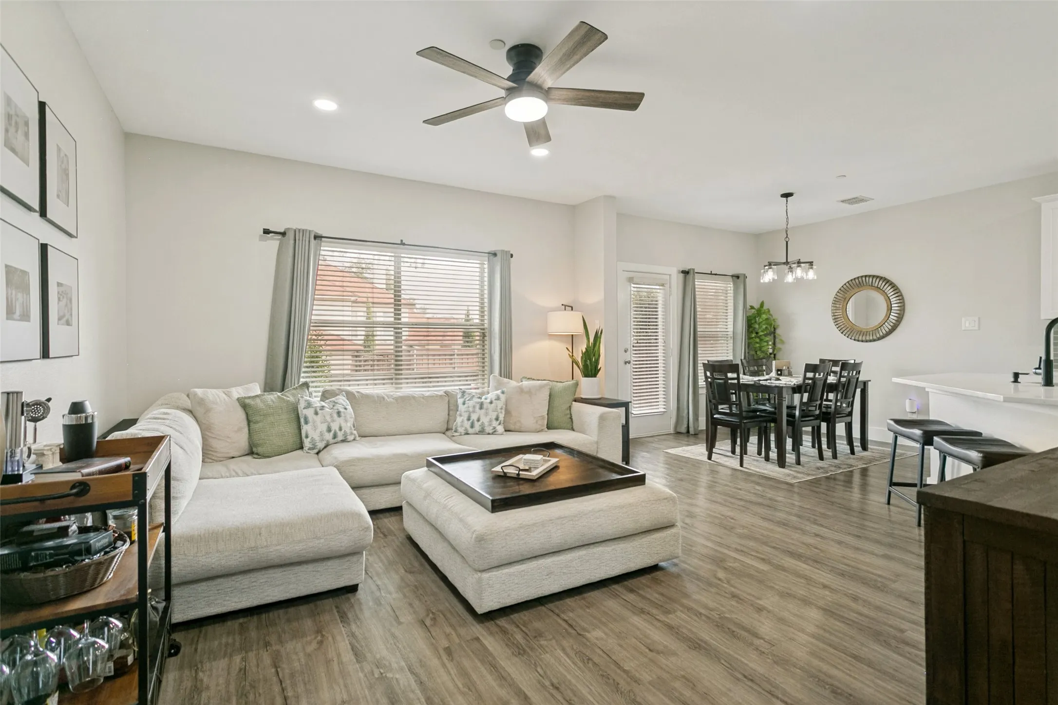 Open-concept living space featuring wood-finish flooring, recessed lighting, and a ceiling fan