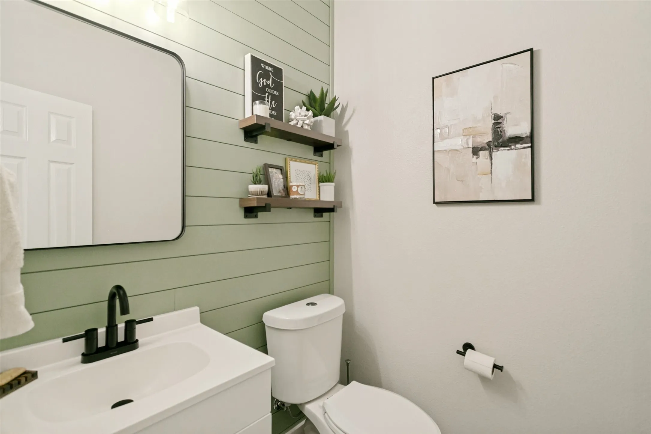 Vanity with integrated sink, matte black faucet, and rectangular mirror