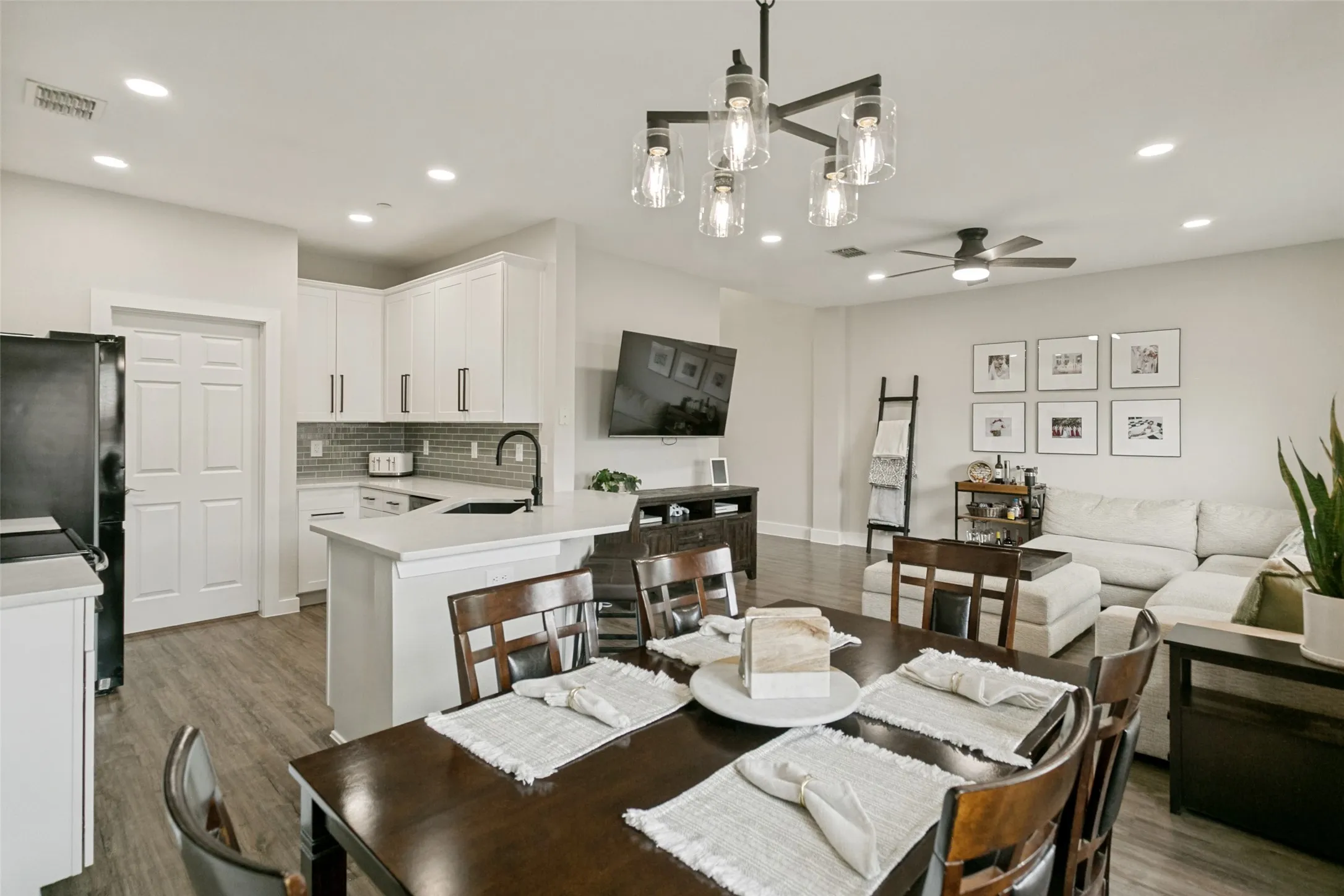 Open-concept living space with wood-finish flooring, recessed lighting, and a modern ceiling fan